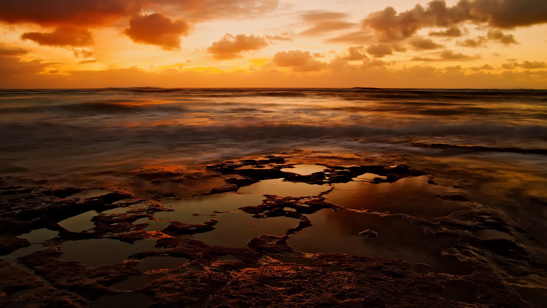 Sunset over the ocean with rocky shore HD Wallpaper