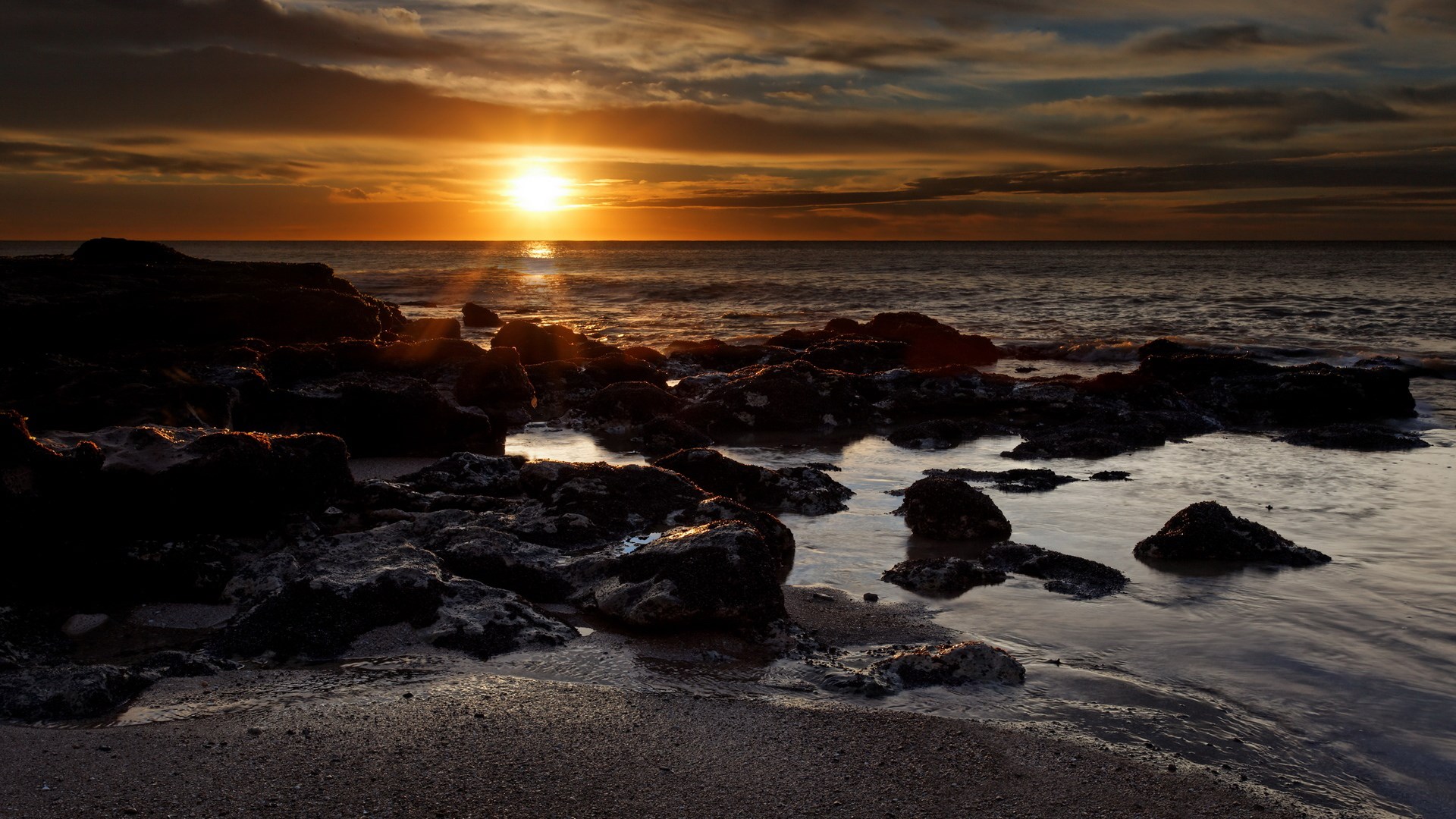 Sunset over rocky coastline with ocean waves HD Wallpaper