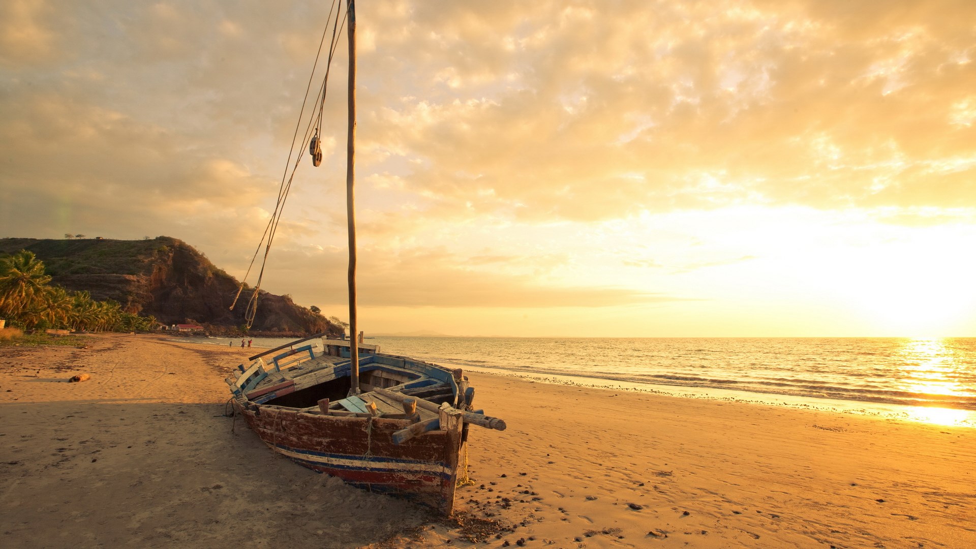 Old wooden boat on a sandy beach at sunset HD Wallpaper