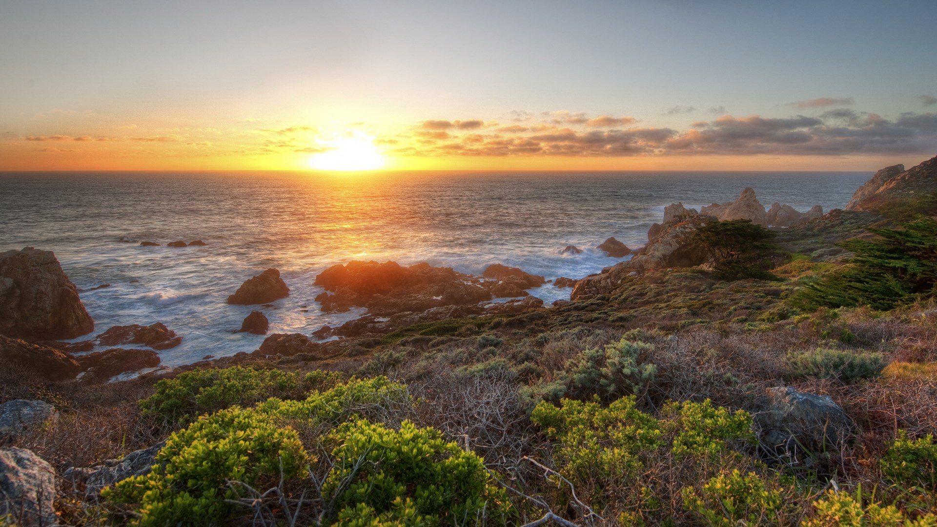 Sunset over rocky coastline with ocean waves HD Wallpaper