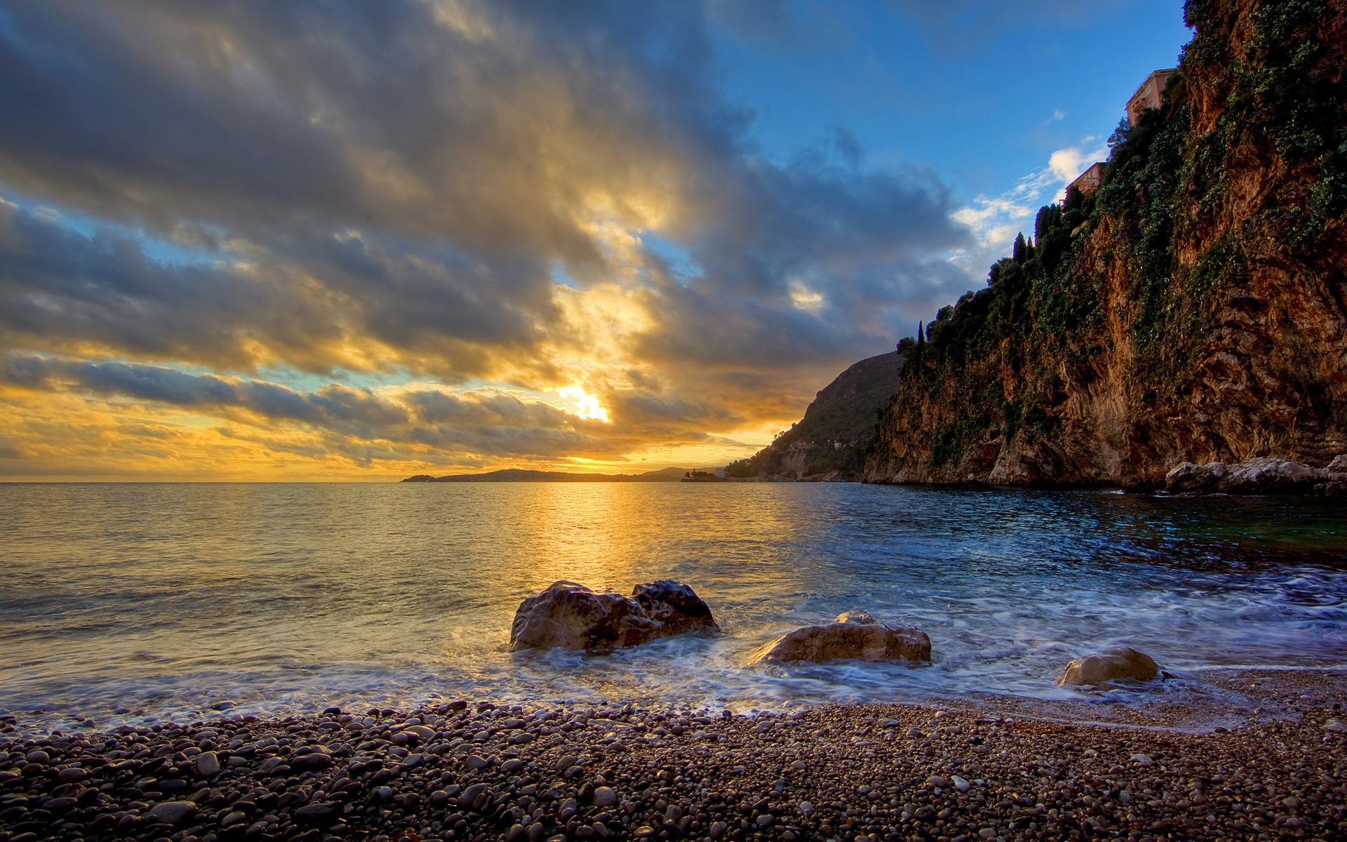 Sunset over a rocky coastline with cliffs and ocean HD Wallpaper