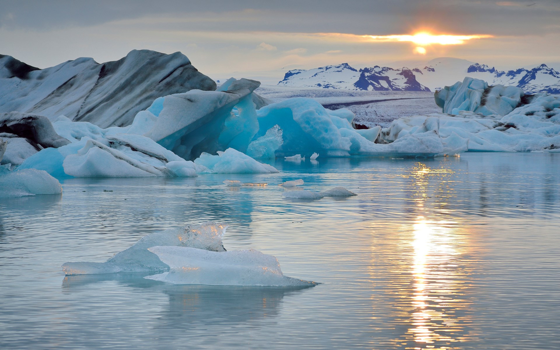 Icebergs floating in glacial lagoon at sunset HD Wallpaper