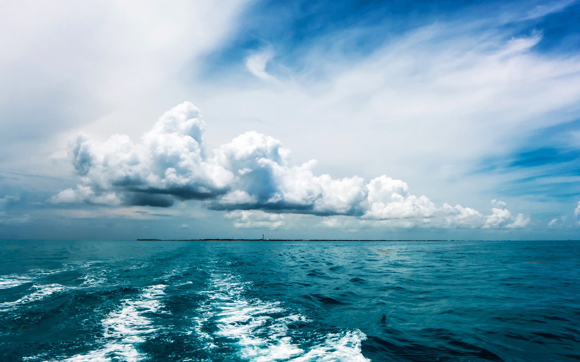 Wake from a boat on the ocean under clouds HD Wallpaper