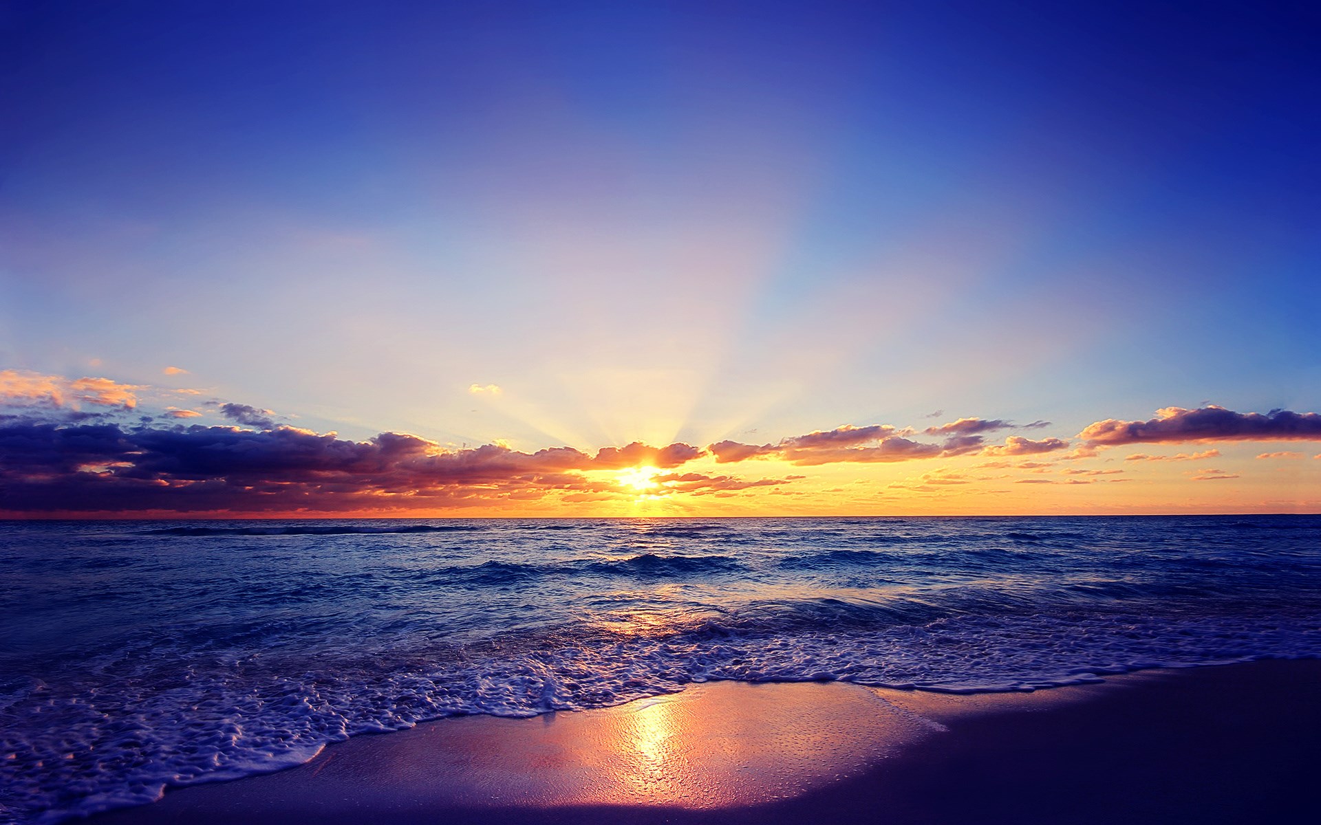 Sunset over the ocean with waves on the shore HD Wallpaper