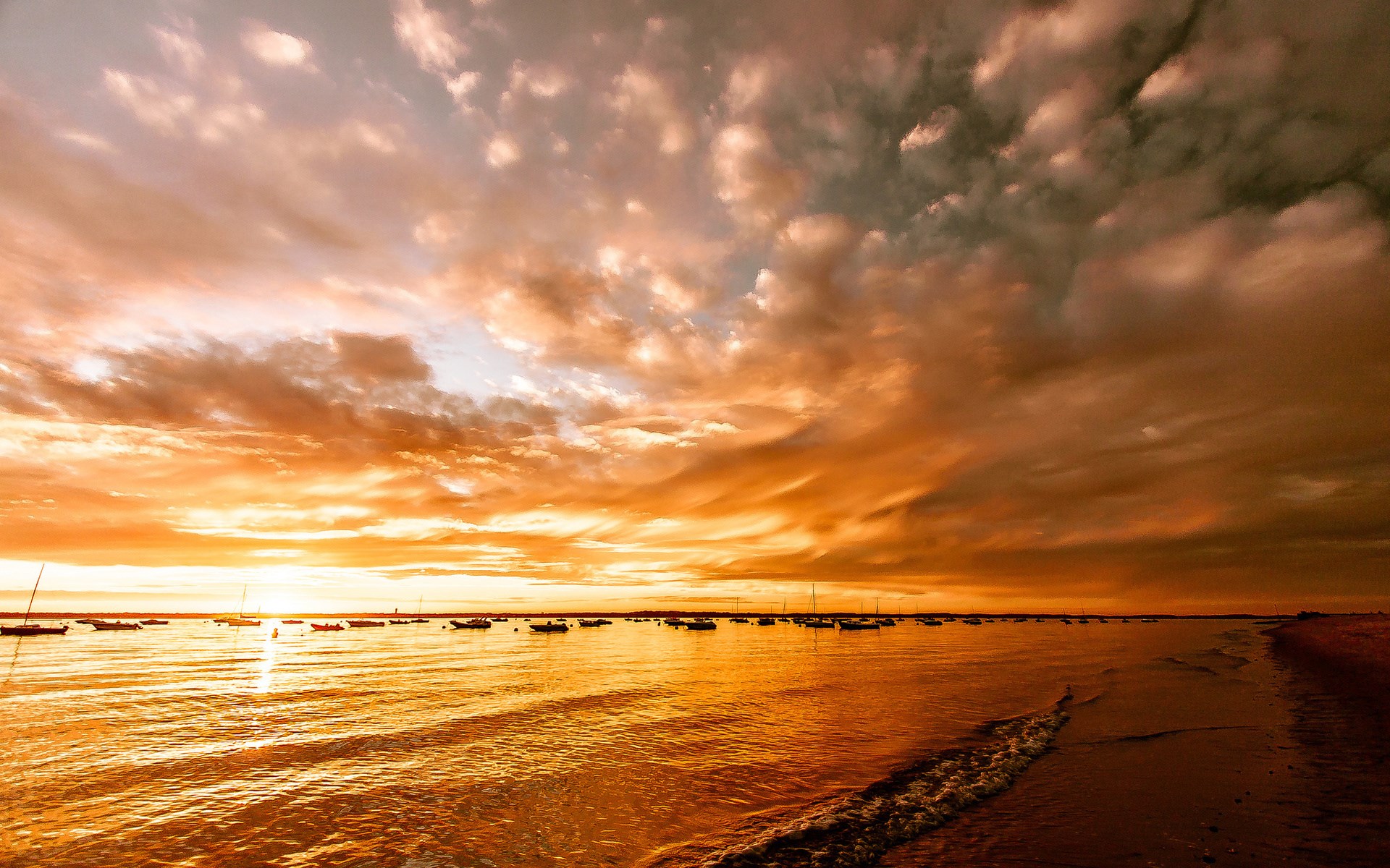 Boats on the water during a vibrant sunset HD Wallpaper