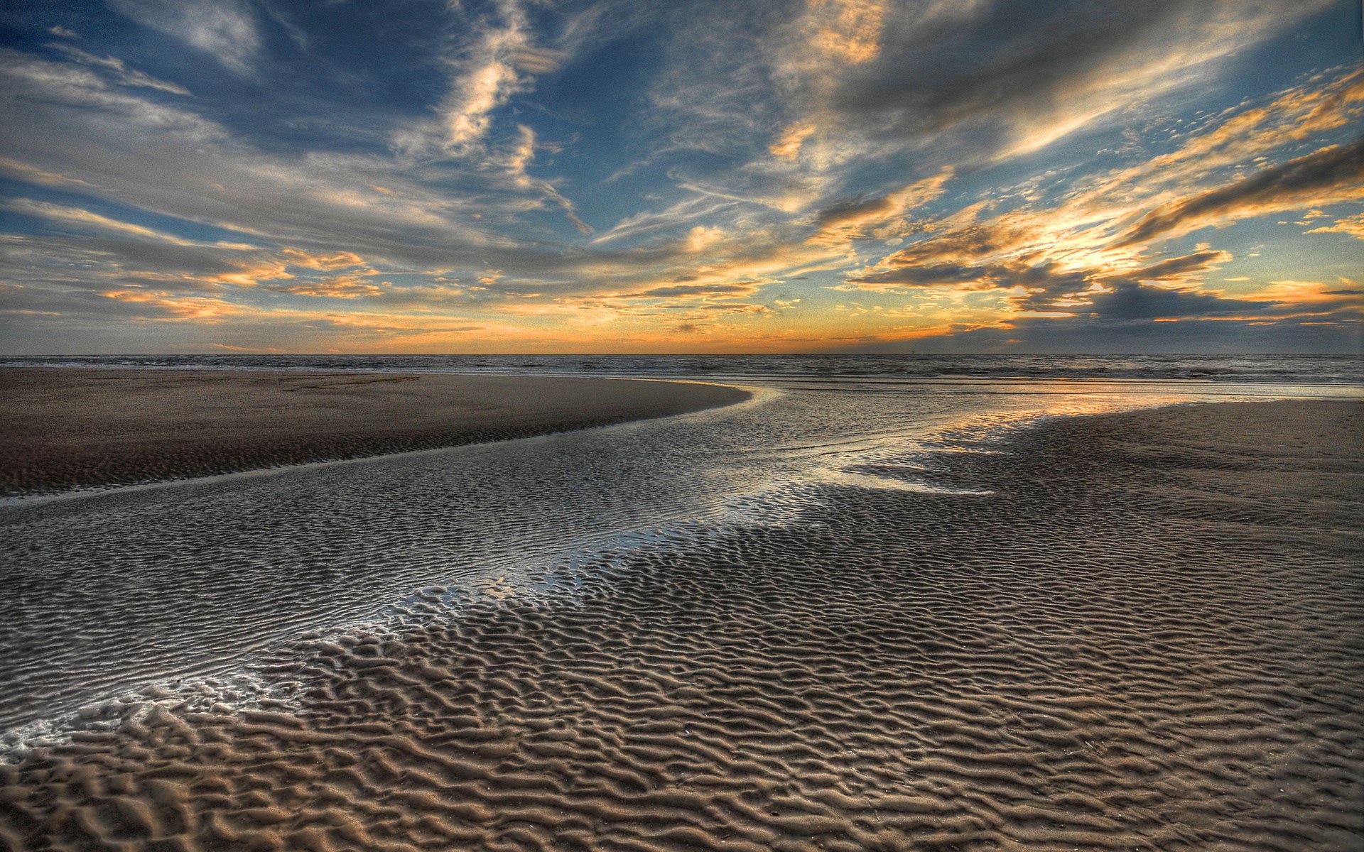 Beach at sunset with rippling sand and clouds HD Wallpaper