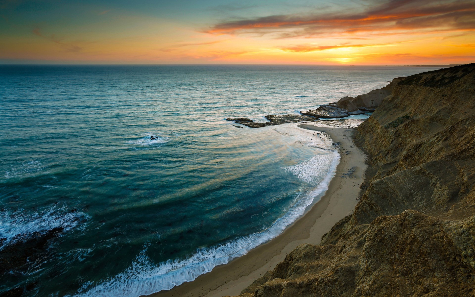 Ocean waves crash on a sandy beach at sunset HD Wallpaper