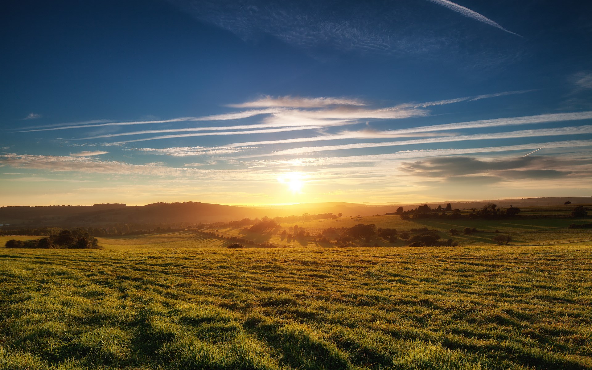 Sunrise over rolling green hills and fields HD Wallpaper