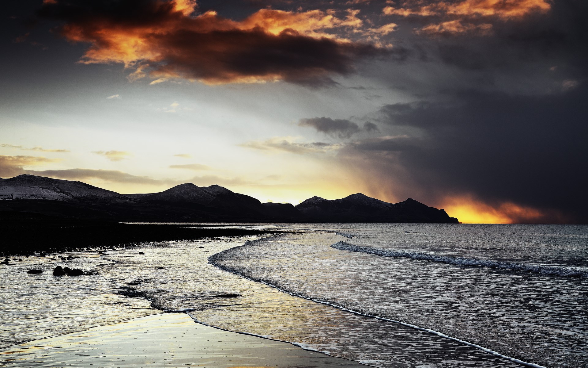 Sunset over a rocky beach and mountains HD Wallpaper
