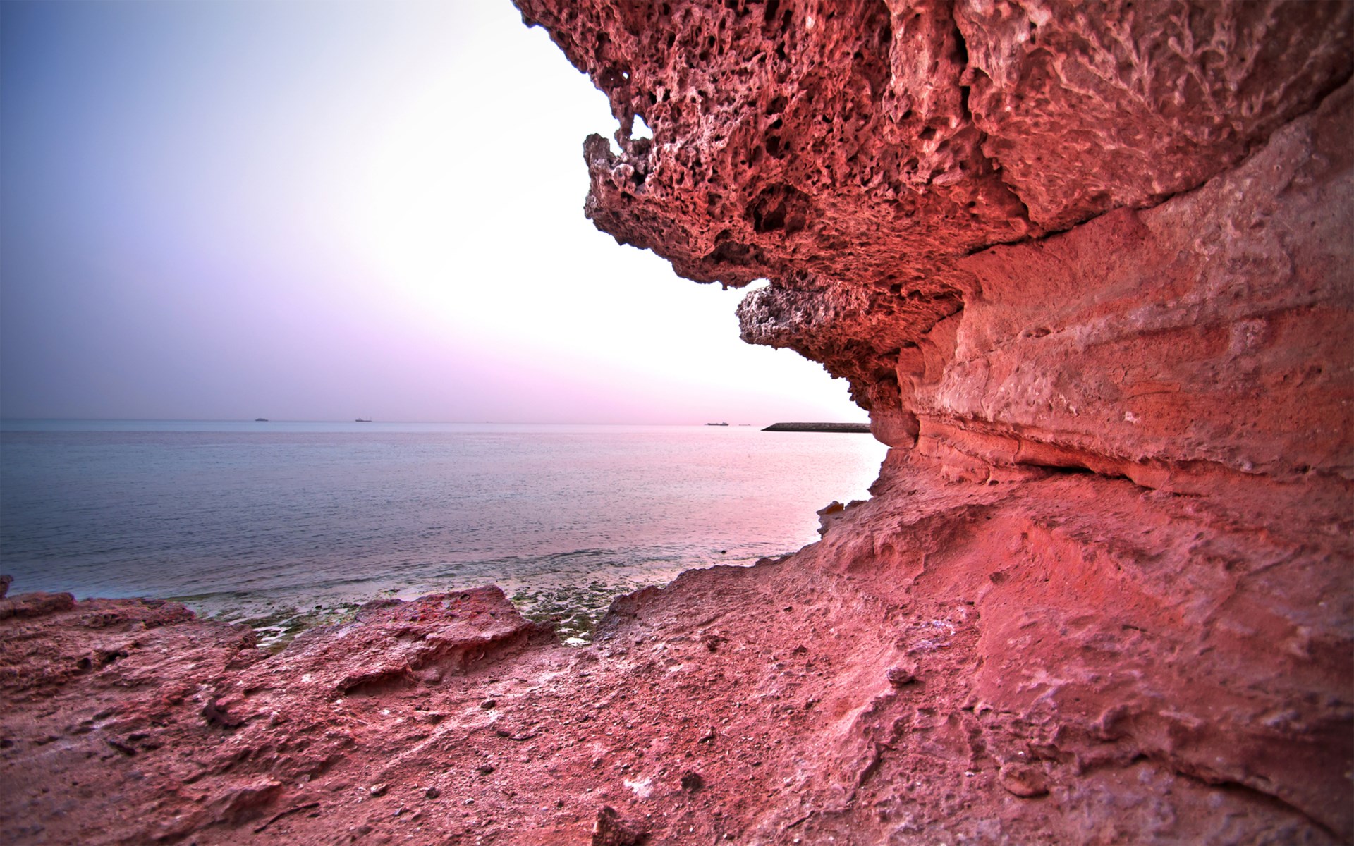 Red rock formations on a beach with the ocean HD Wallpaper