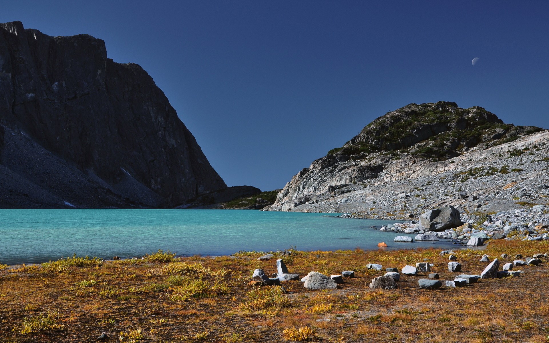 Turquoise lake between mountains with moon in sky HD Wallpaper
