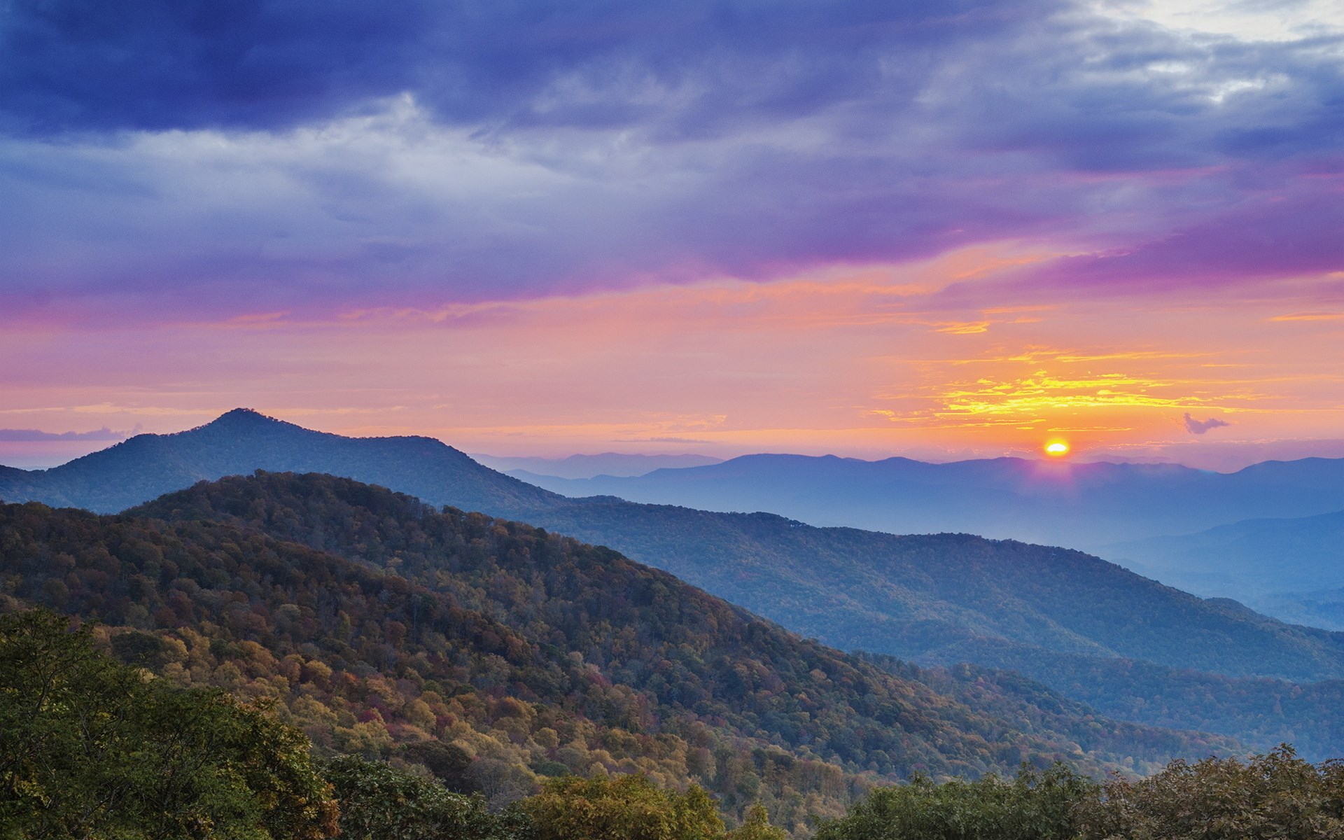 Mountain range at sunset with colorful clouds HD Wallpaper