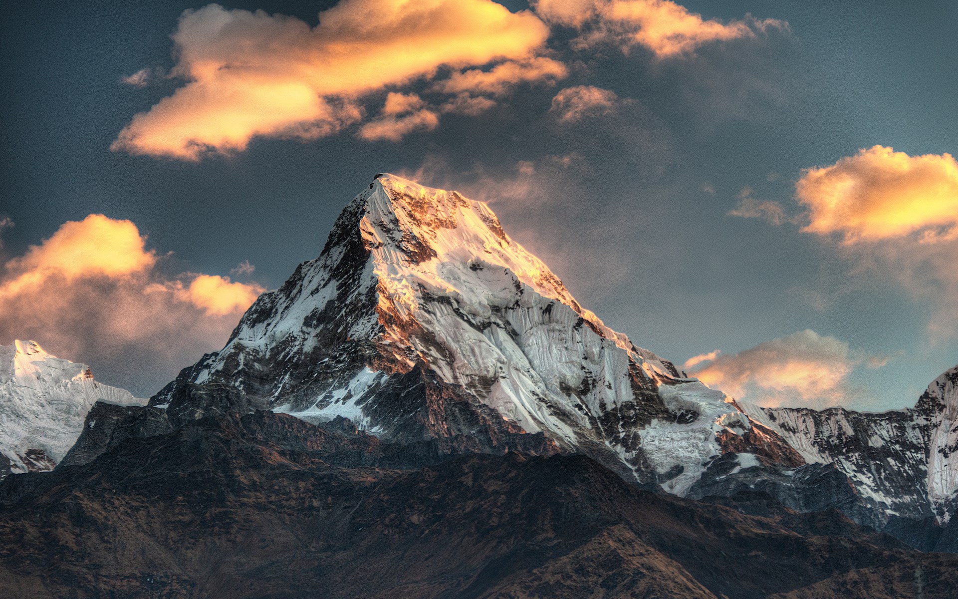 Snow-capped mountain peak at sunset with clouds HD Wallpaper