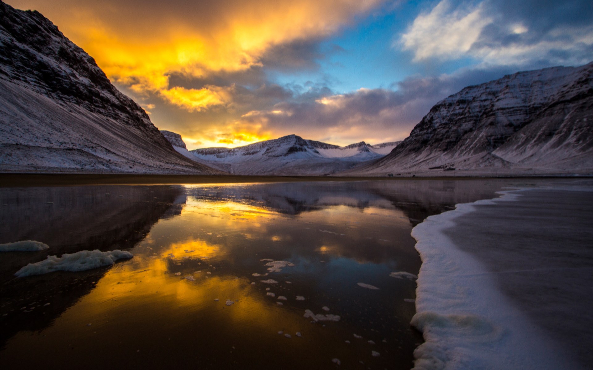 Snowy mountains reflected in a calm body of water during sunset HD Wallpaper