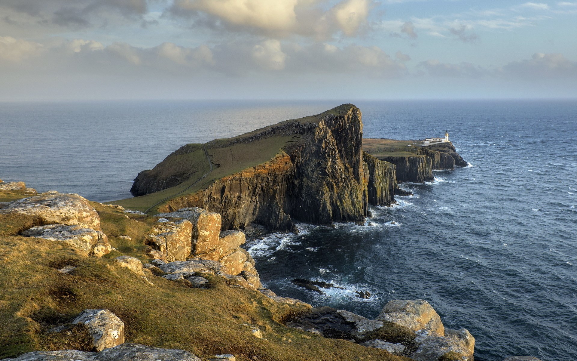 Neist Point Lighthouse on a rocky cliff overlooking the sea HD Wallpaper