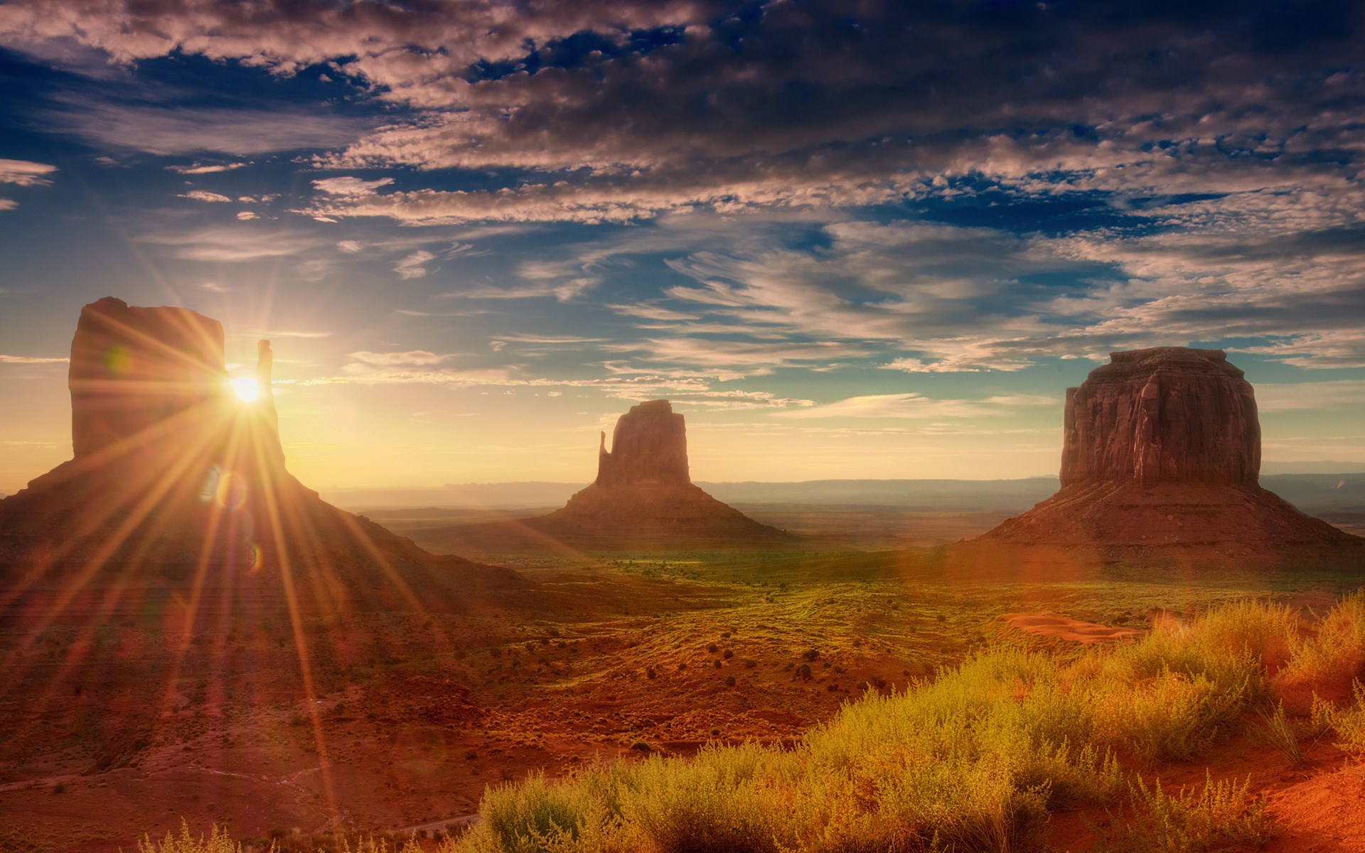 Monument Valley at sunrise with sun flares HD Wallpaper