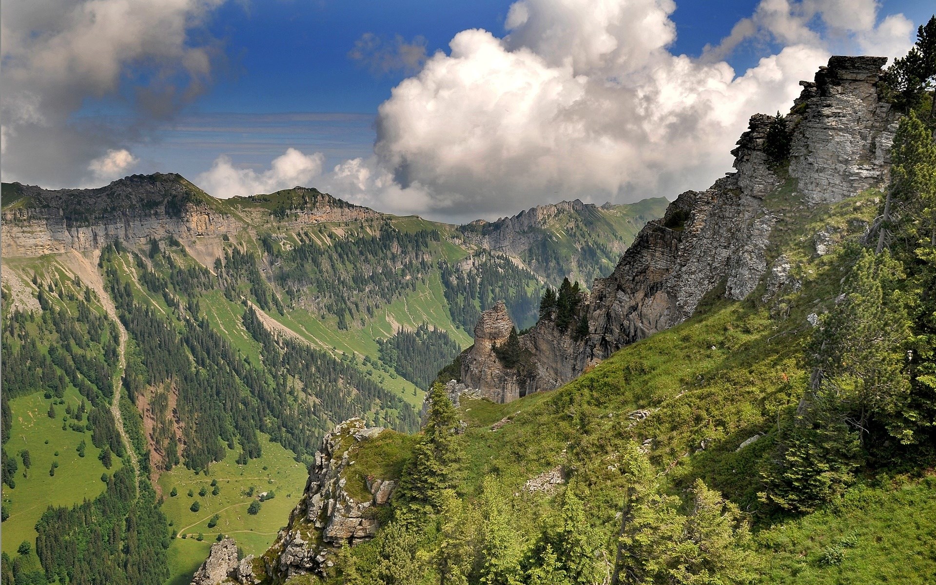 Mountain valley with rocky peaks and green slopes HD Wallpaper