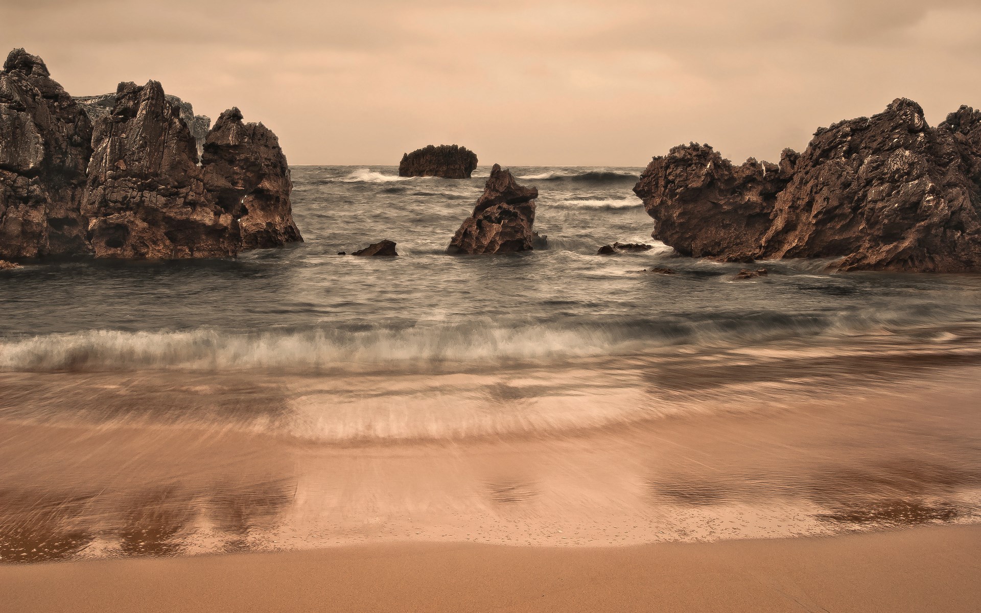 Rocky coast with waves crashing on a sandy beach HD Wallpaper