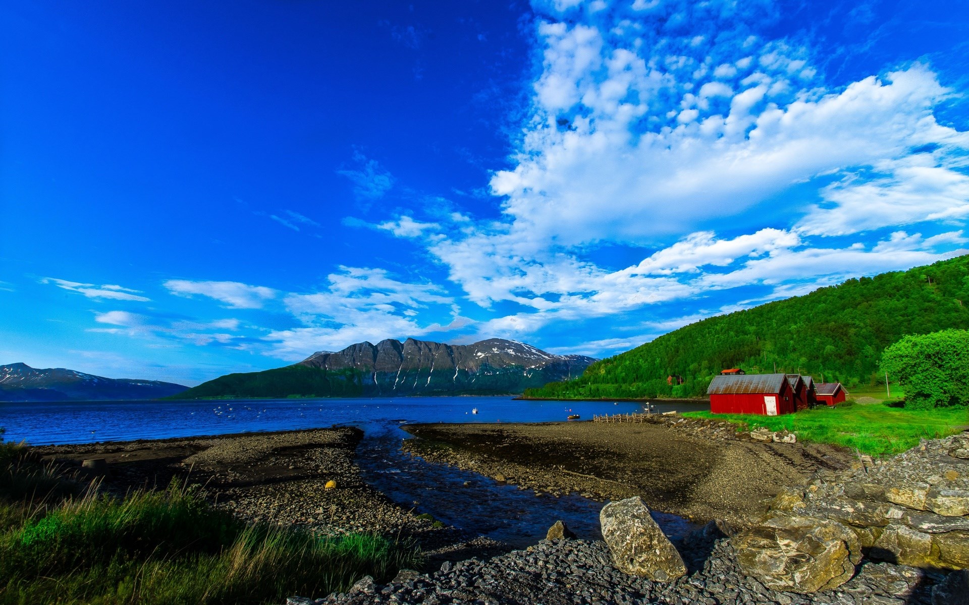 Red cabins by a lake with mountains and blue sky HD Wallpaper