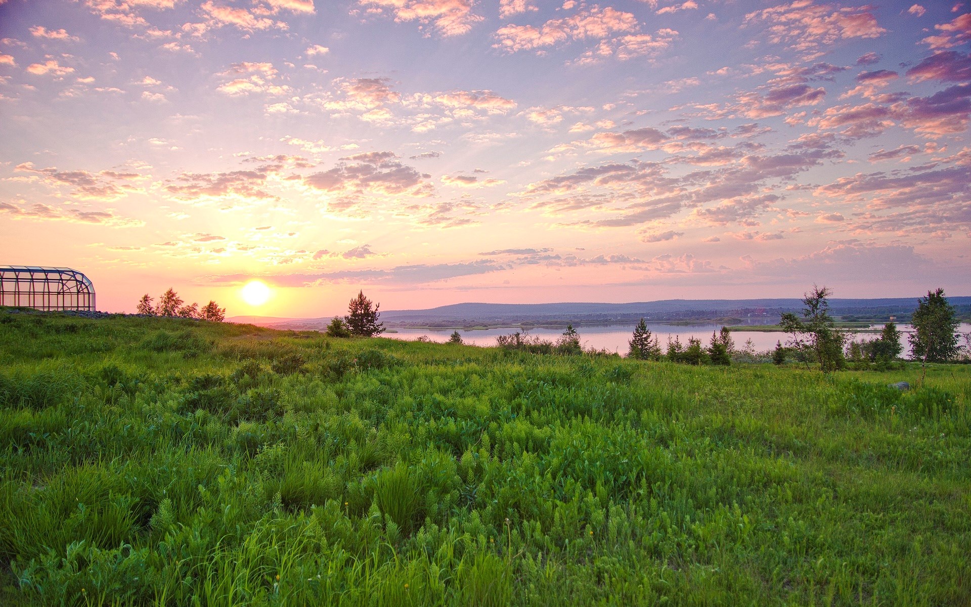 Sunset over a grassy field and river HD Wallpaper