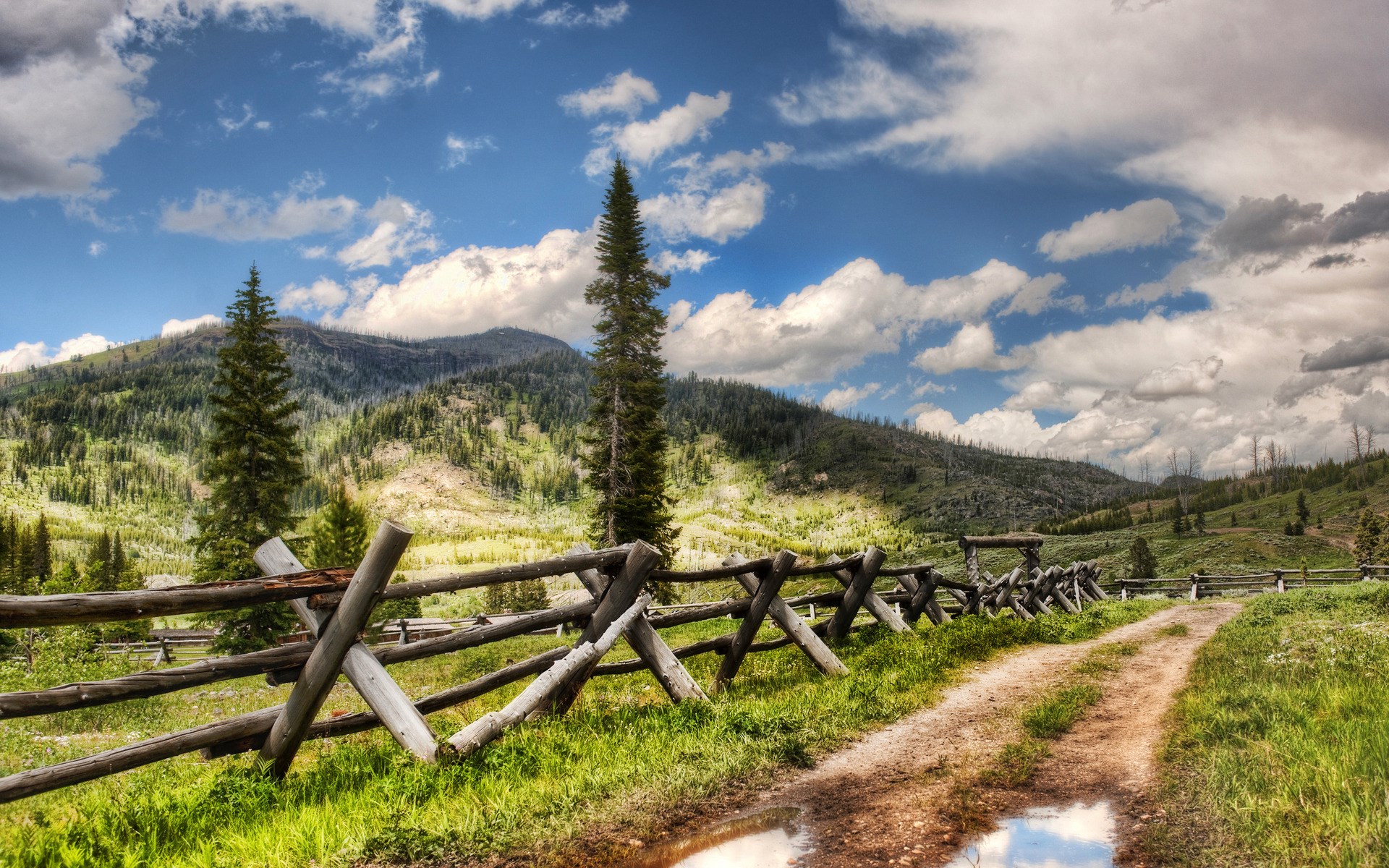 Dirt road with wooden fence and mountains HD Wallpaper