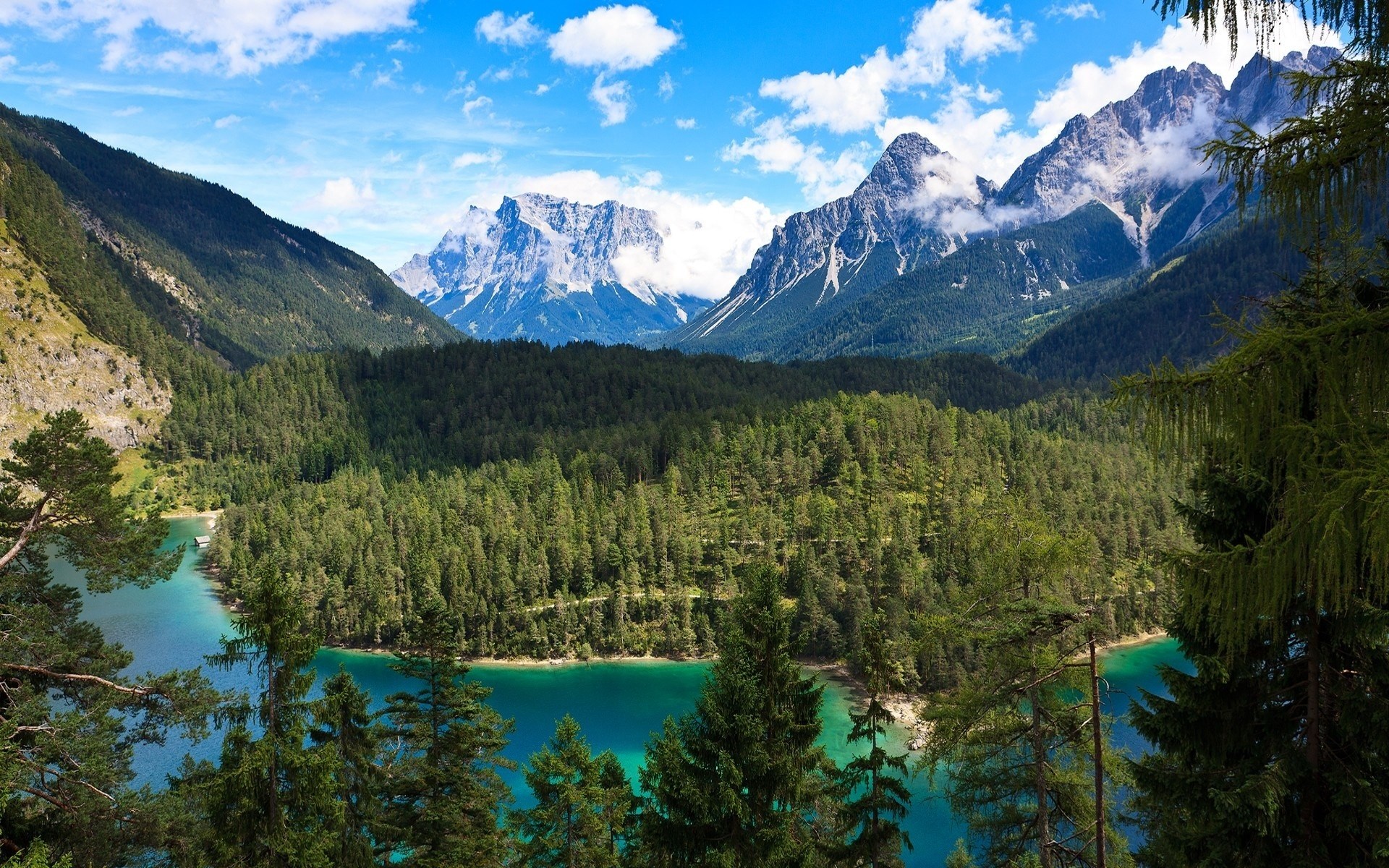 Turquoise lake surrounded by pine forest and mountains HD Wallpaper