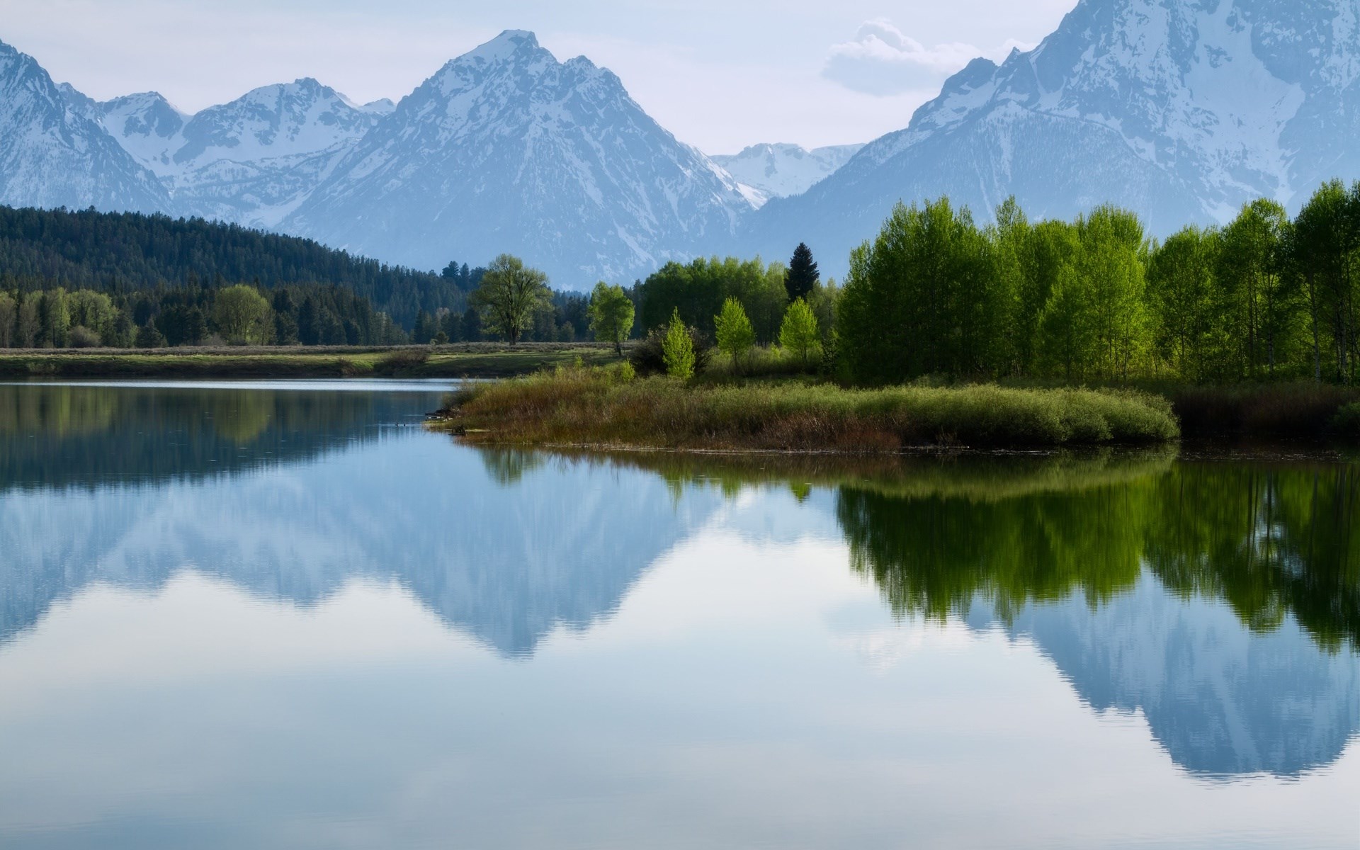 Snow-capped mountains reflected in a calm lake HD Wallpaper