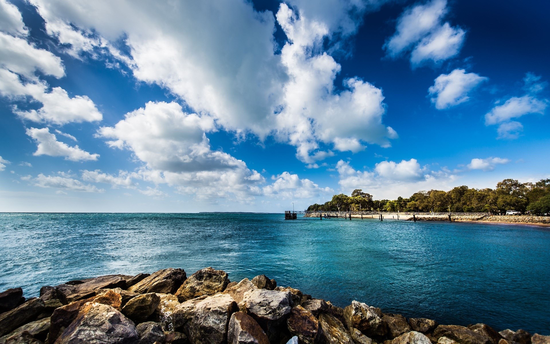 Rocky shore and blue ocean with cloudy sky HD Wallpaper