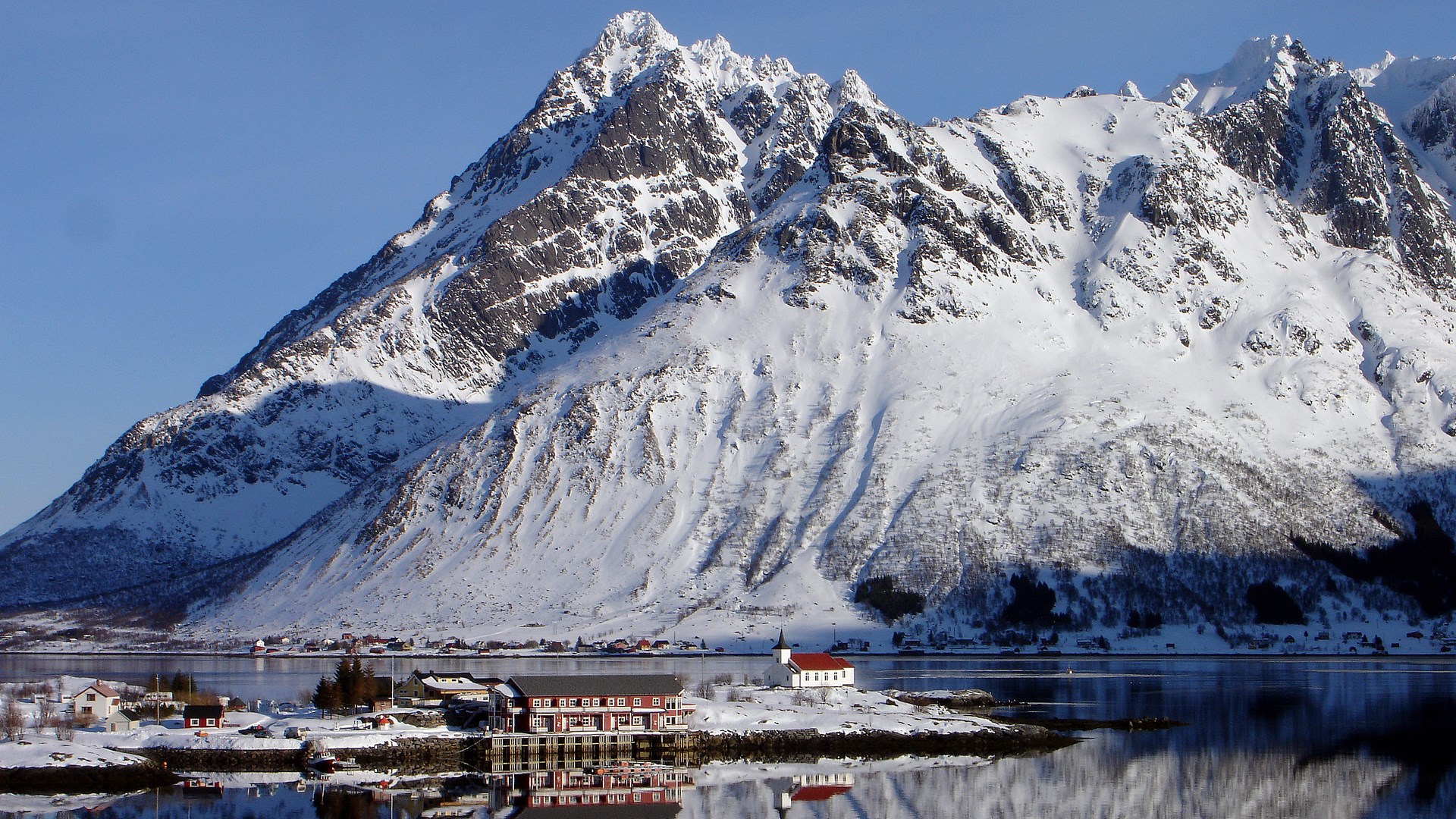 Snowy Mountains Overlooking a Coastal Village and Fjord HD Wallpaper