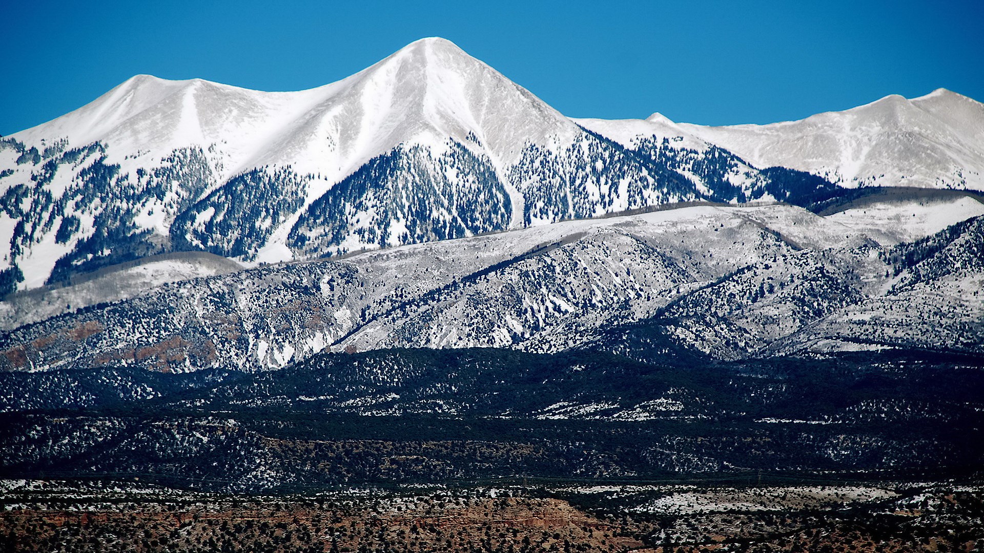 Snow-covered mountains under a clear blue sky HD Wallpaper
