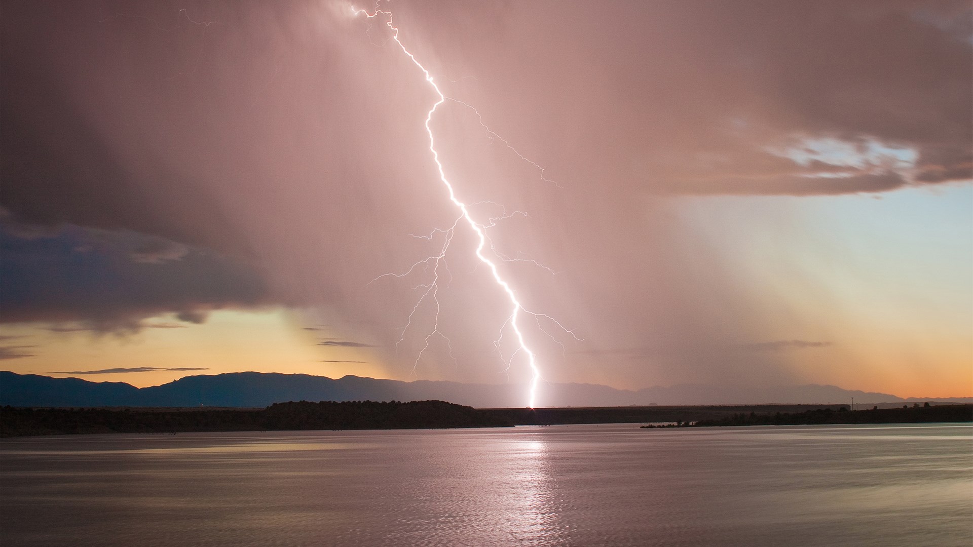 Lightning strike over a lake at sunset HD Wallpaper
