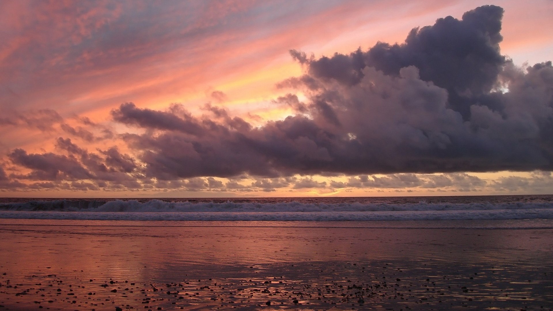 Sunset over a beach with dramatic clouds and waves HD Wallpaper
