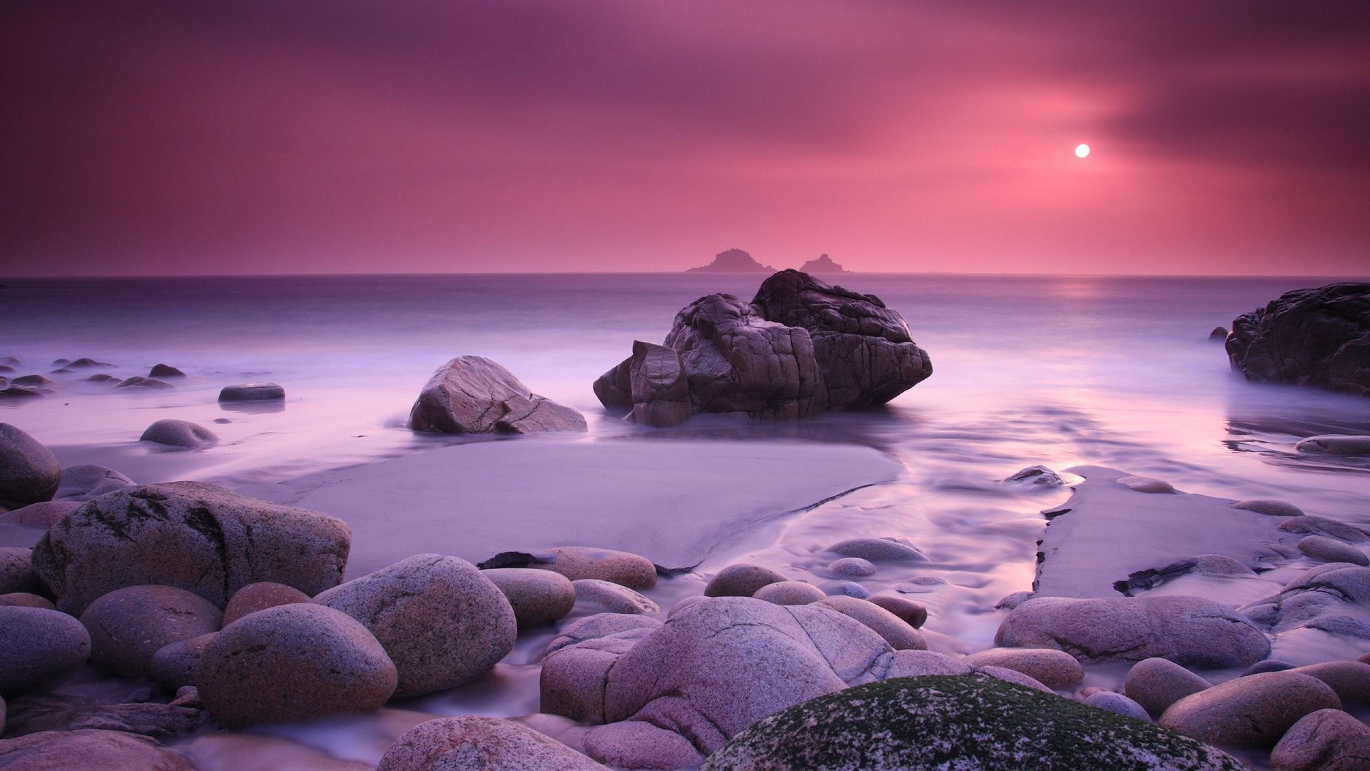 Purple sunset over rocky beach with ocean waves HD Wallpaper