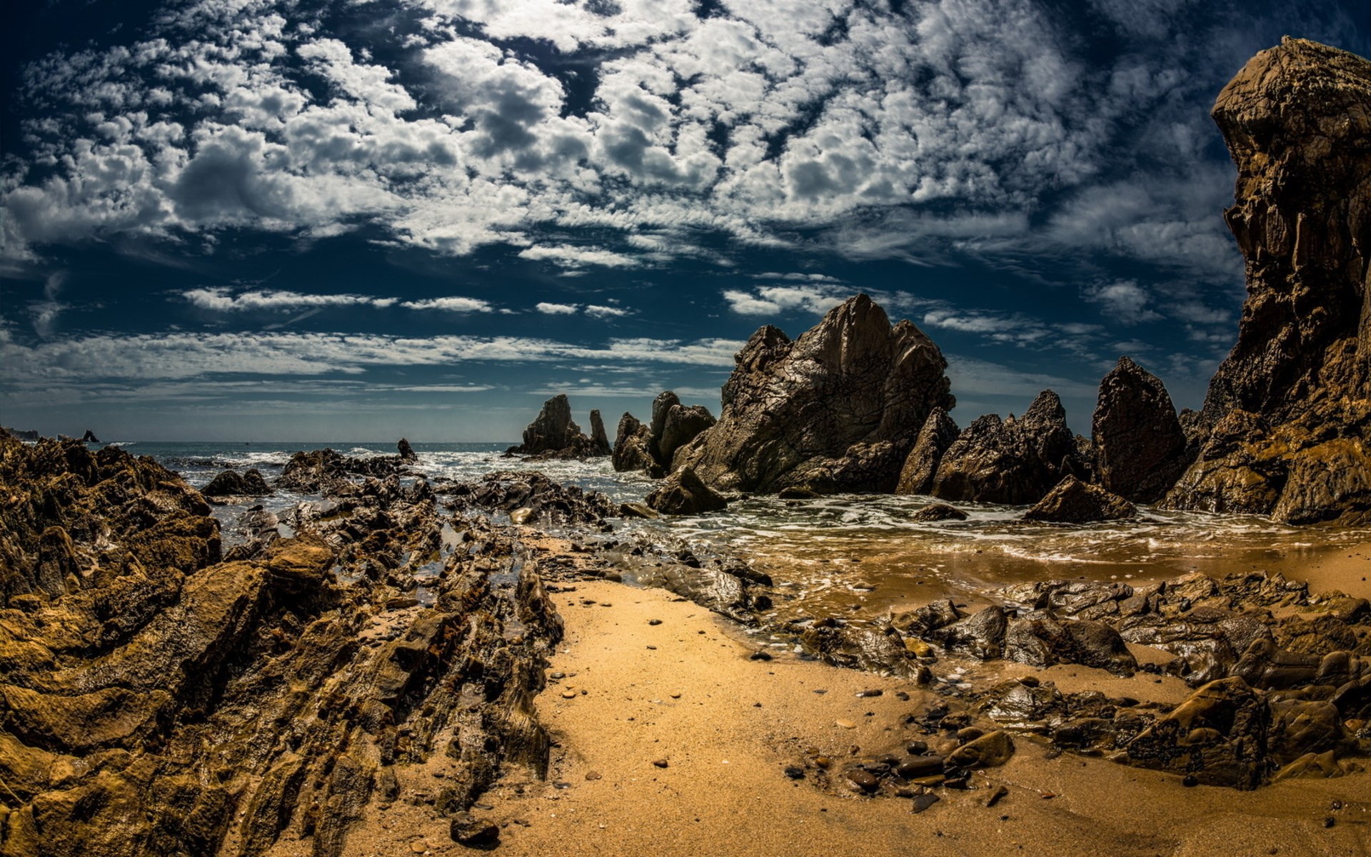 Rocky coastline with dramatic clouds and ocean waves HD Wallpaper
