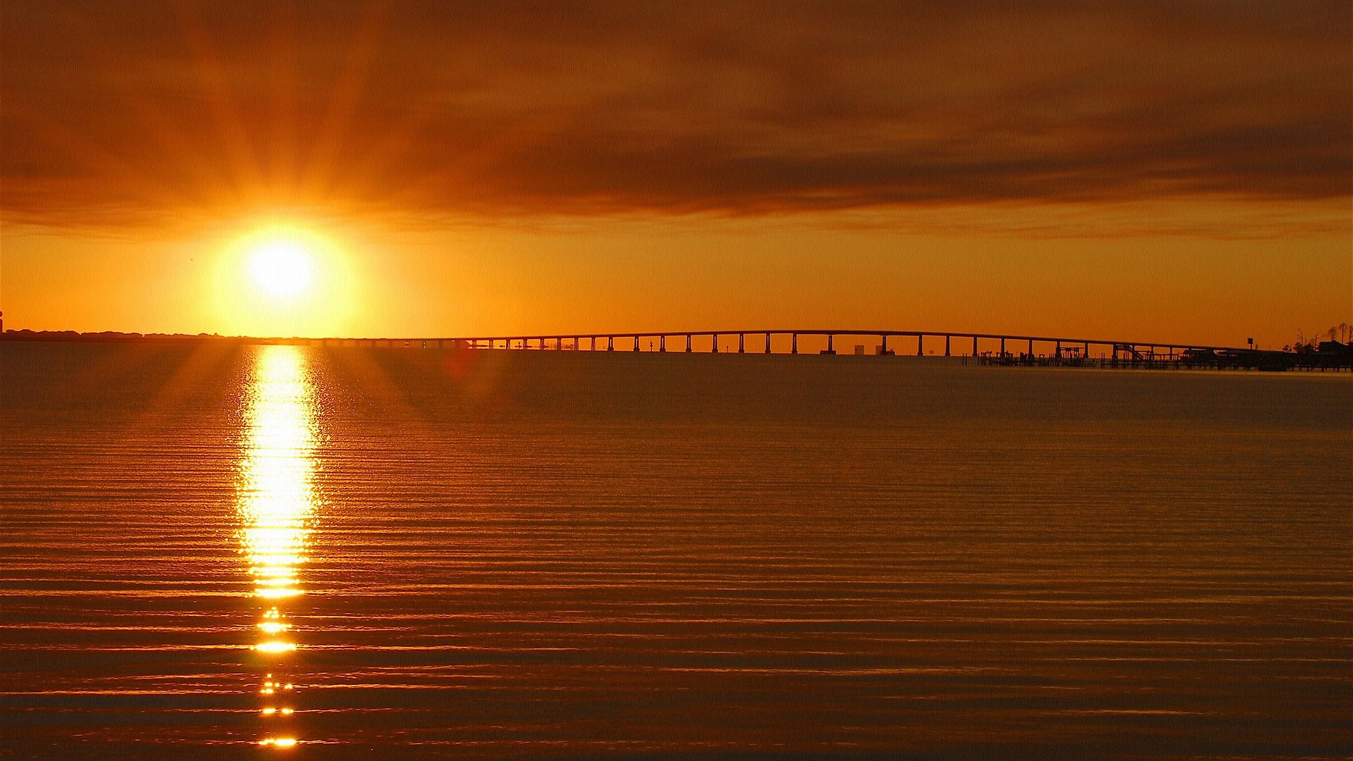 Sunset over a bridge and ocean HD Wallpaper