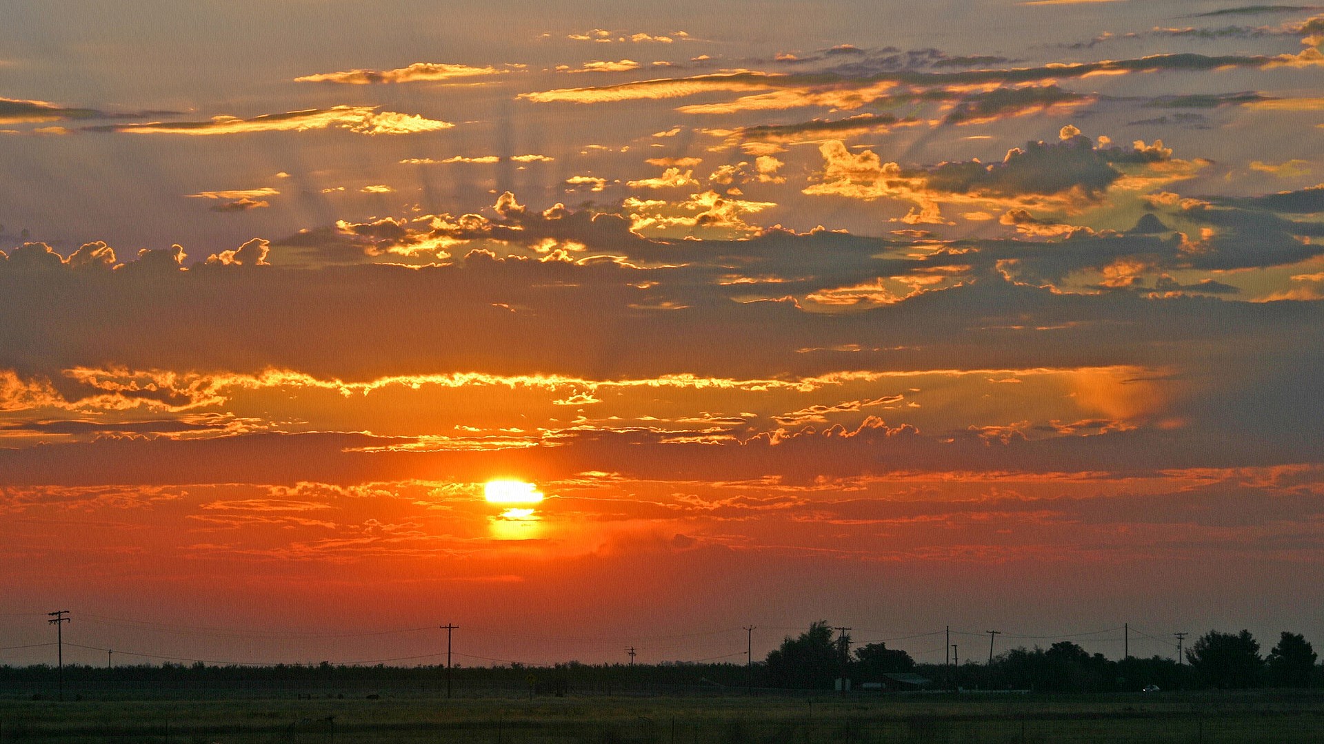 Sunset over a rural landscape with power lines HD Wallpaper