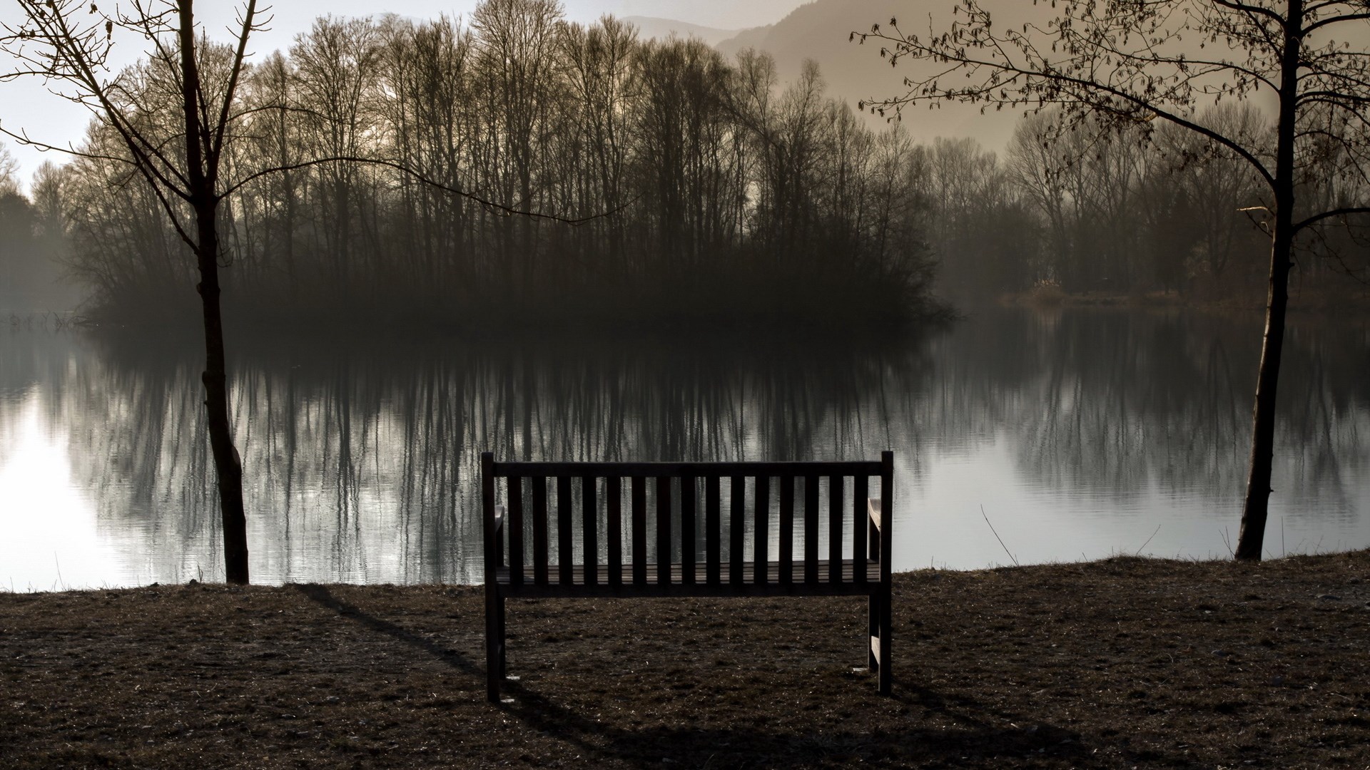 Bench by a lake with trees and mountains HD Wallpaper