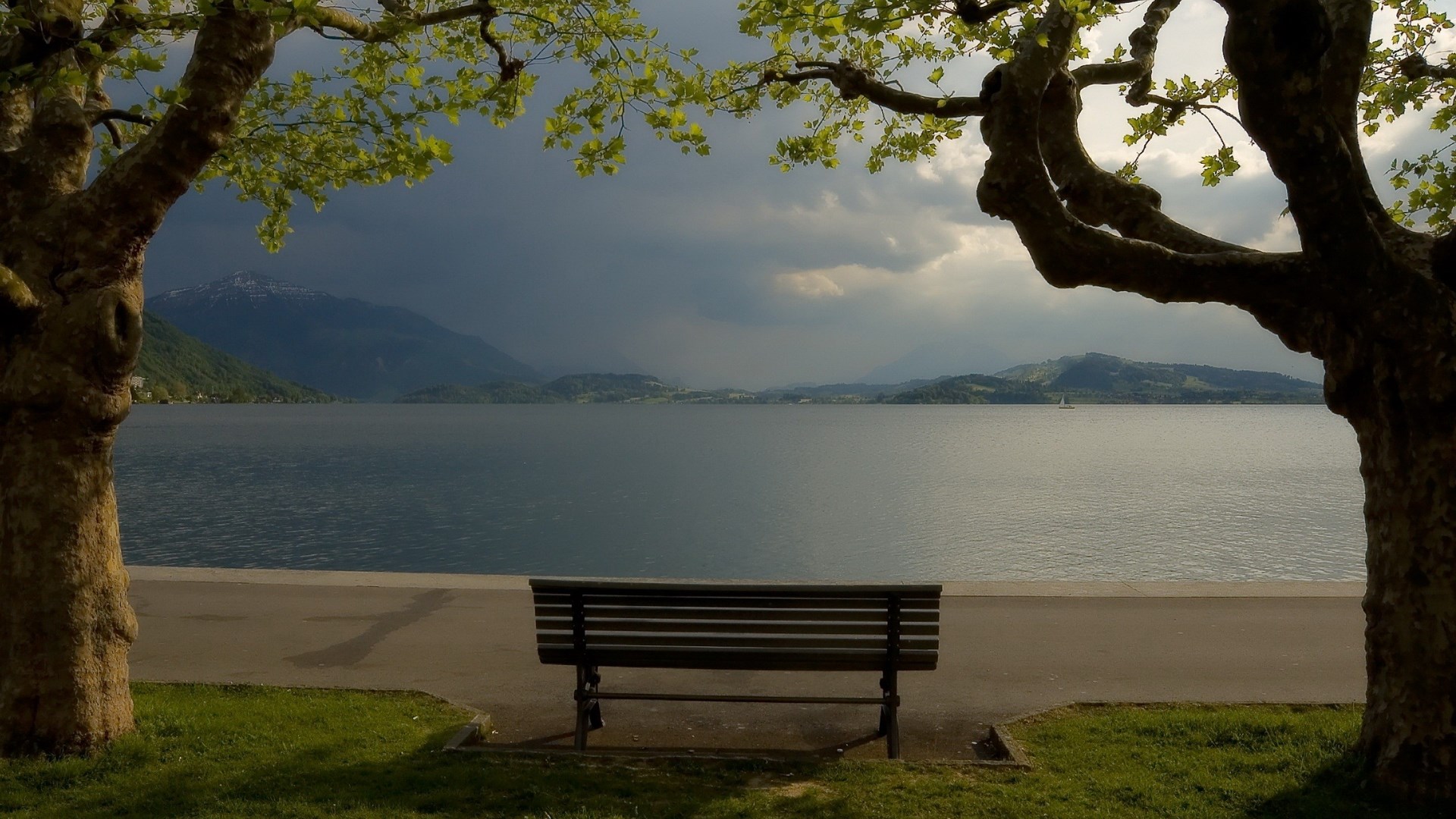 Bench overlooking a lake with mountains HD Wallpaper