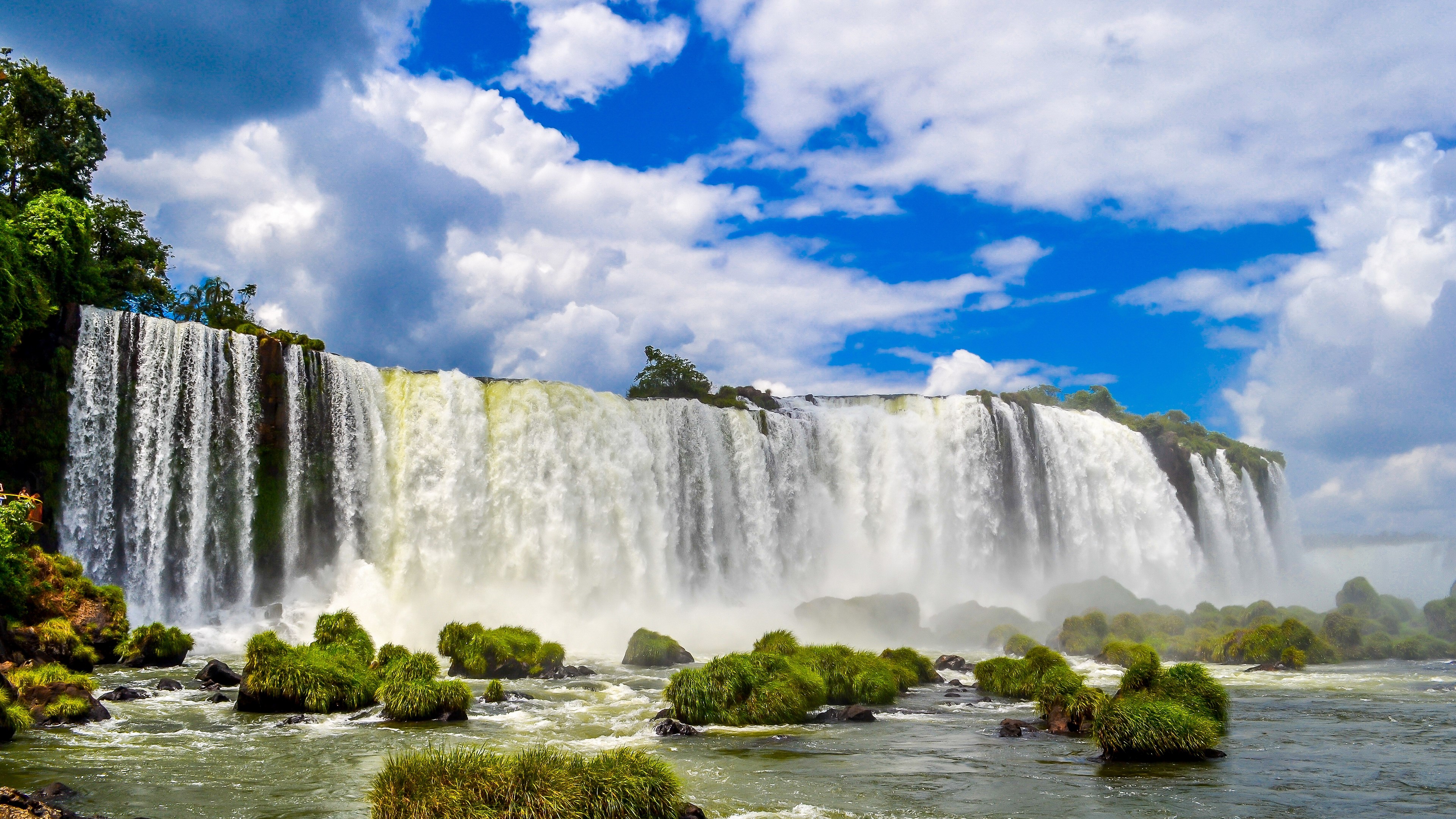 Wide waterfall with green rocks and blue sky HD Wallpaper