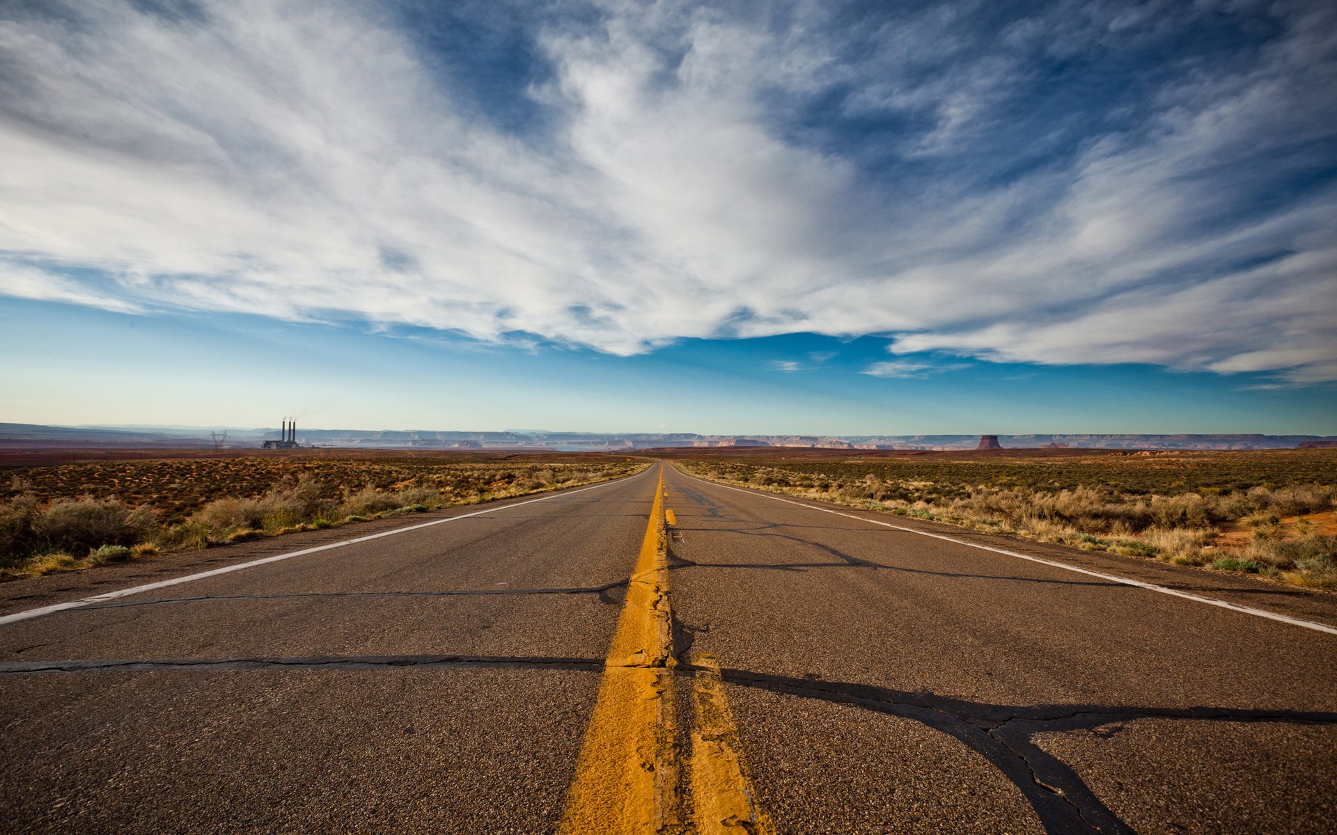 Desert highway with power plant in the distance HD Wallpaper