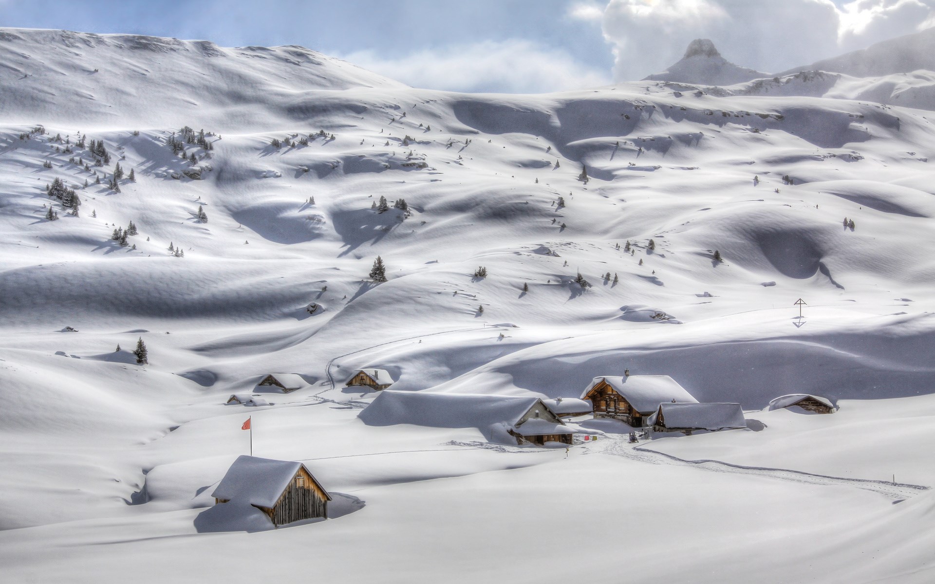 Snowy mountain landscape with cabins and a flag HD Wallpaper