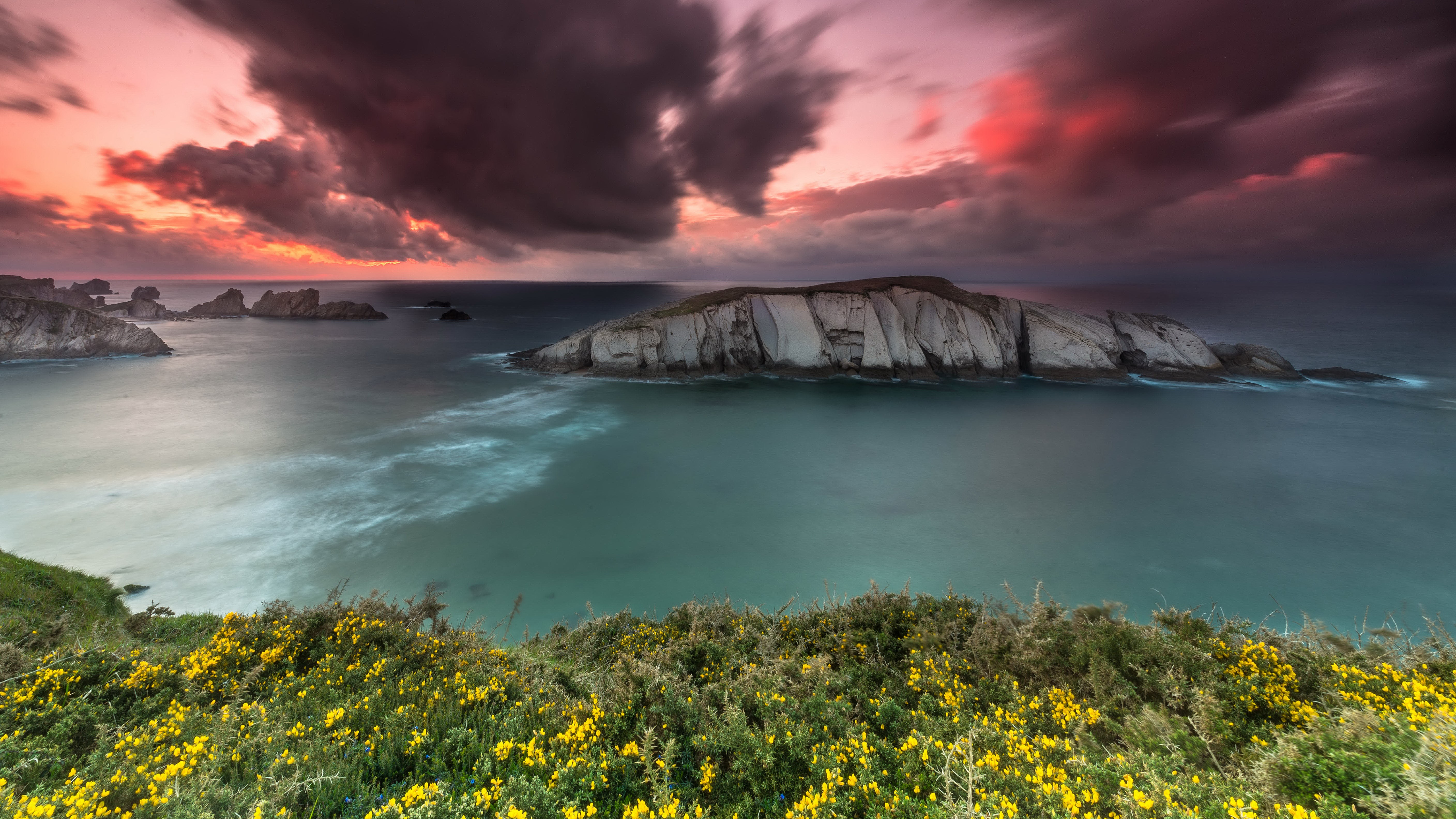 Rocky coastline with island and dramatic sunset sky HD Wallpaper