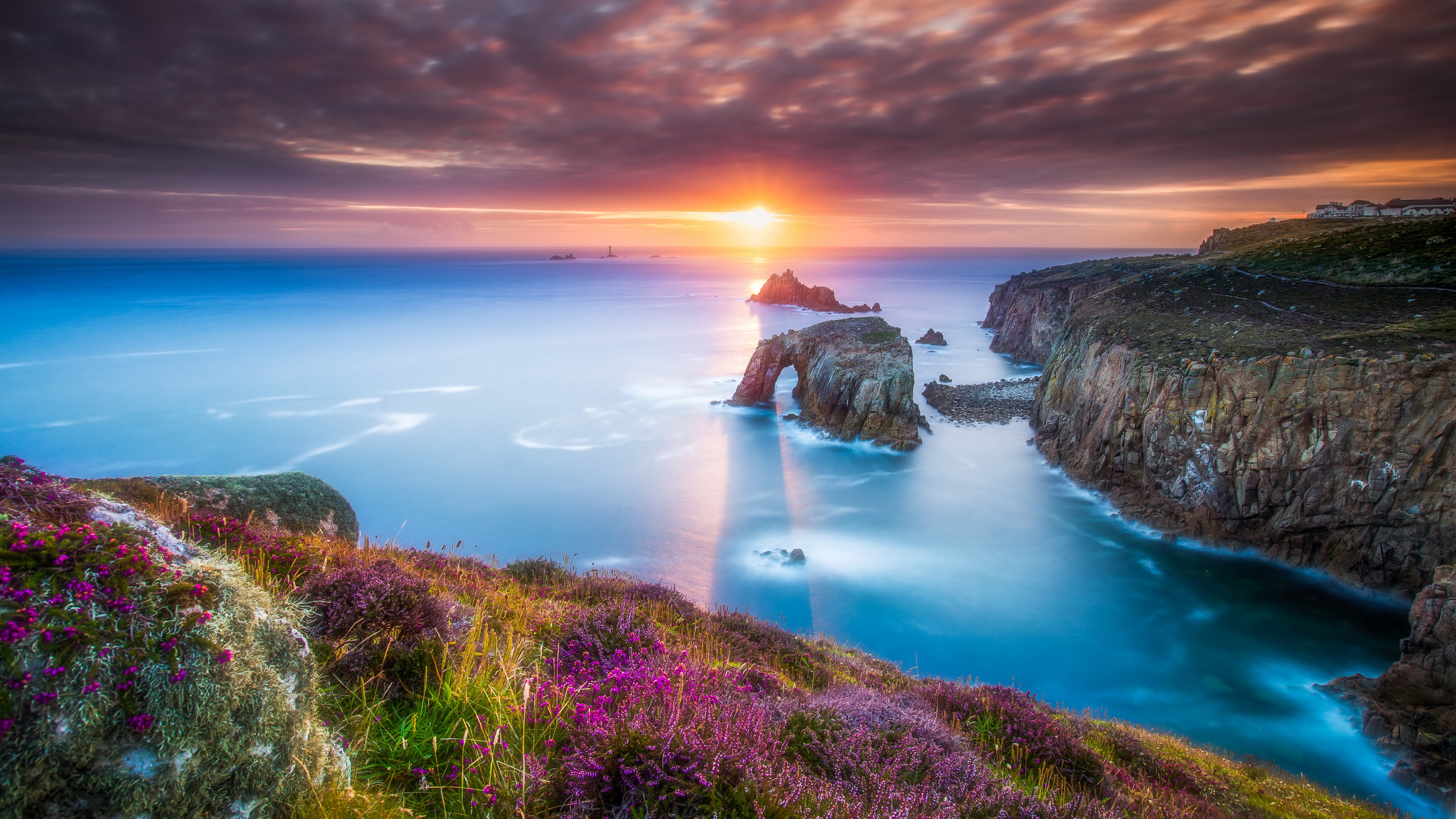 Sunset over rocky coastline with sea arch HD Wallpaper