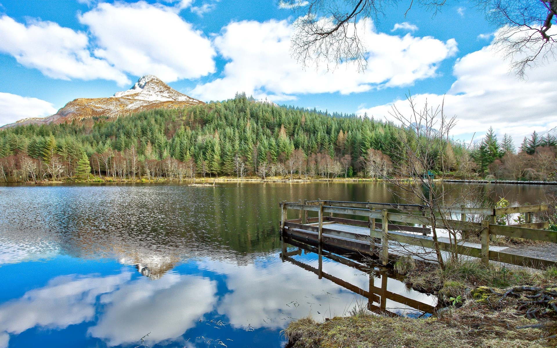Wooden pier on a lake with a snow-capped mountain and forest HD Wallpaper