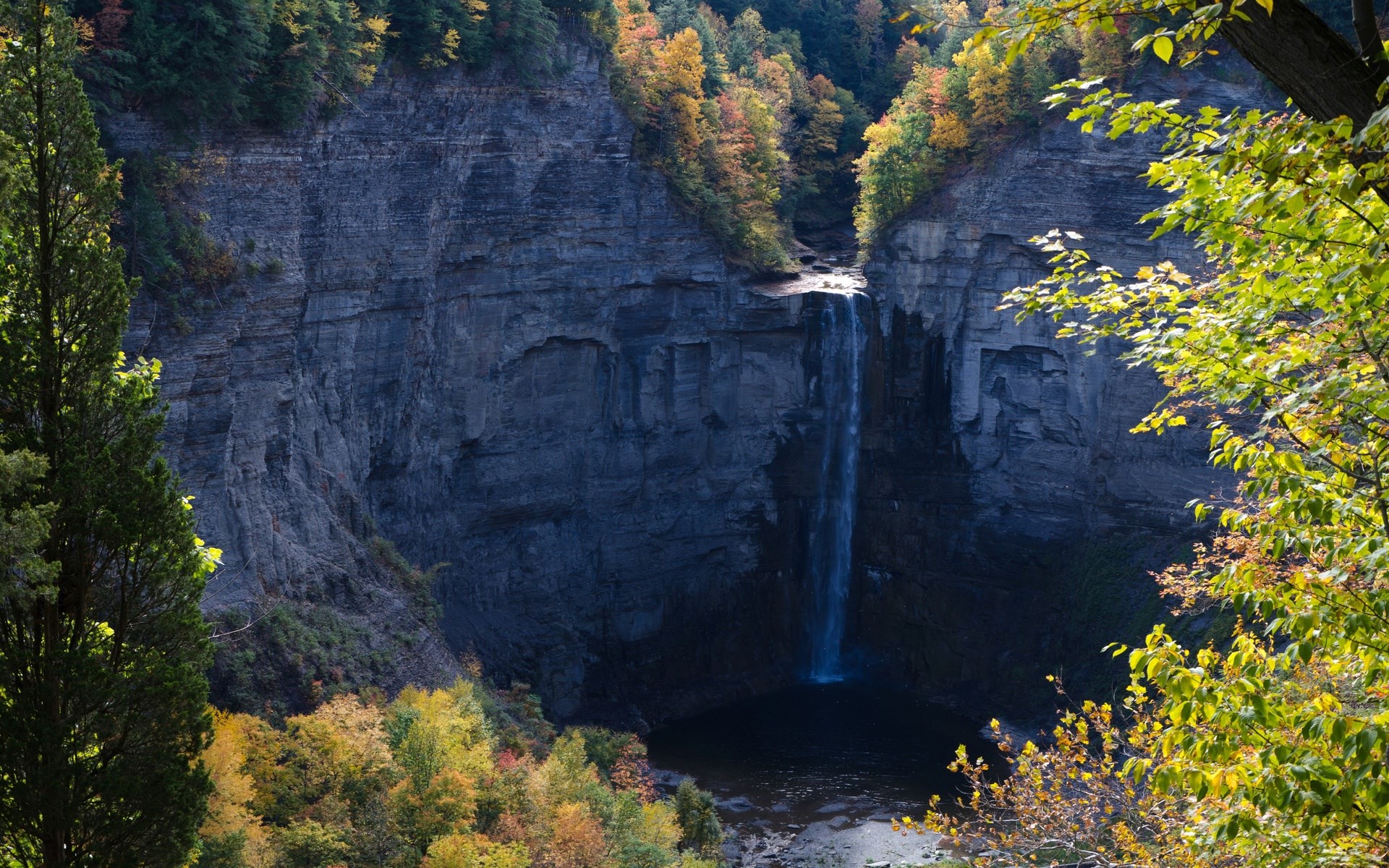 Waterfall cascading down a rocky cliff face in autumn HD Wallpaper
