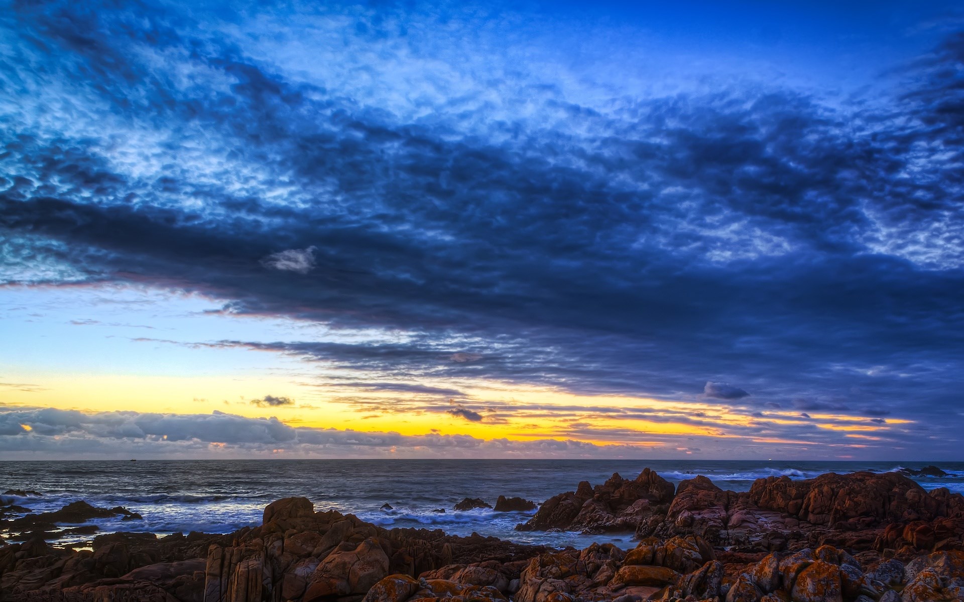 Rocky coastline at sunset with dramatic clouds HD Wallpaper