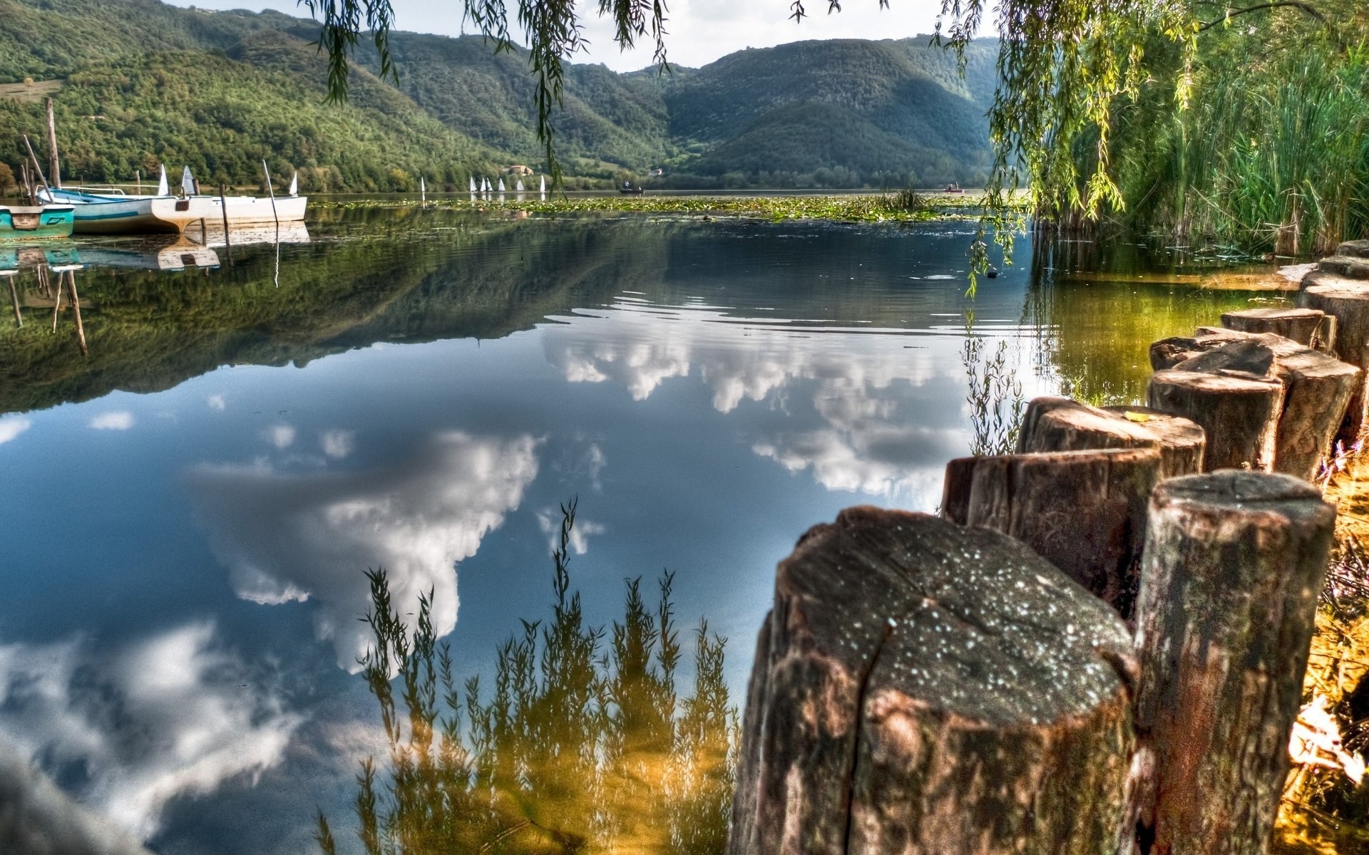 Lake with boats and reflections of mountains and clouds HD Wallpaper
