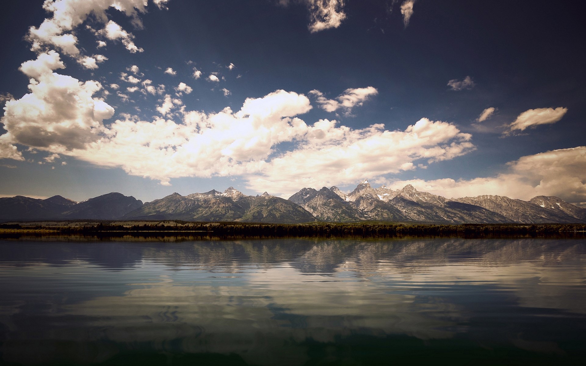 Mountains reflected in a lake under a cloudy sky HD Wallpaper