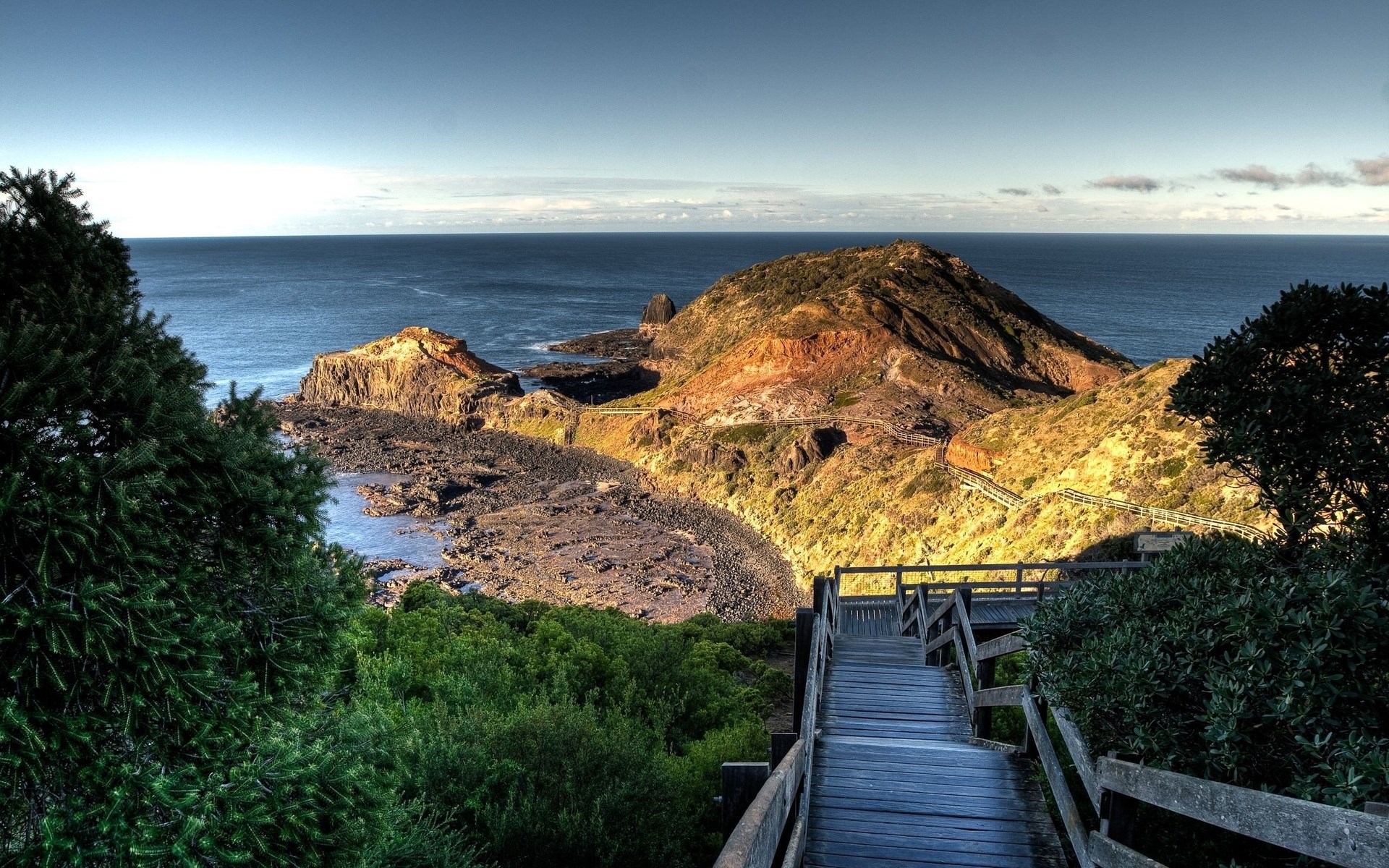 Wooden boardwalk overlooking a rocky coastline and ocean HD Wallpaper