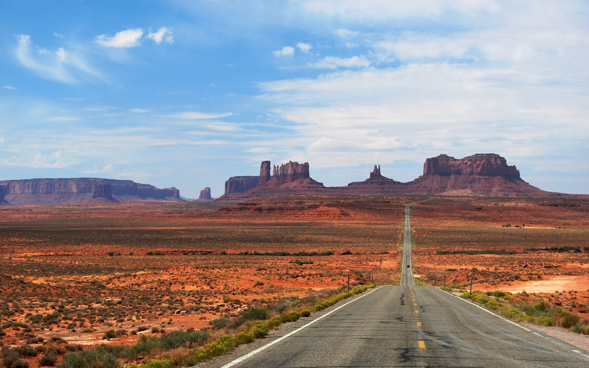 Monument Valley road with mesas under a blue sky HD Wallpaper